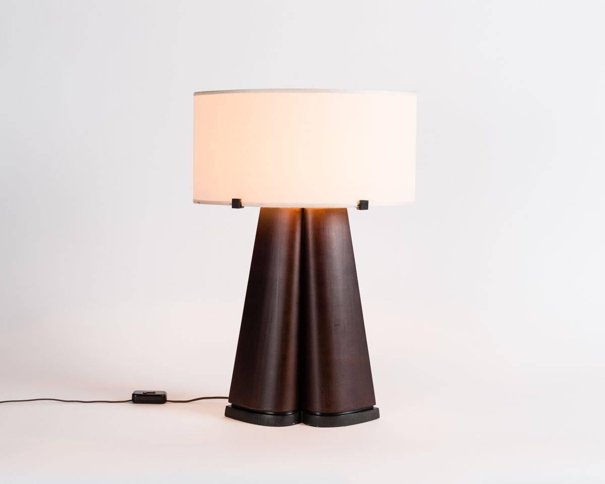 This parchment clad table lamp by Achille Salvagni has a symmetrical, siamese shape as well as a broad silk shade that gently balances the piece's wide base.