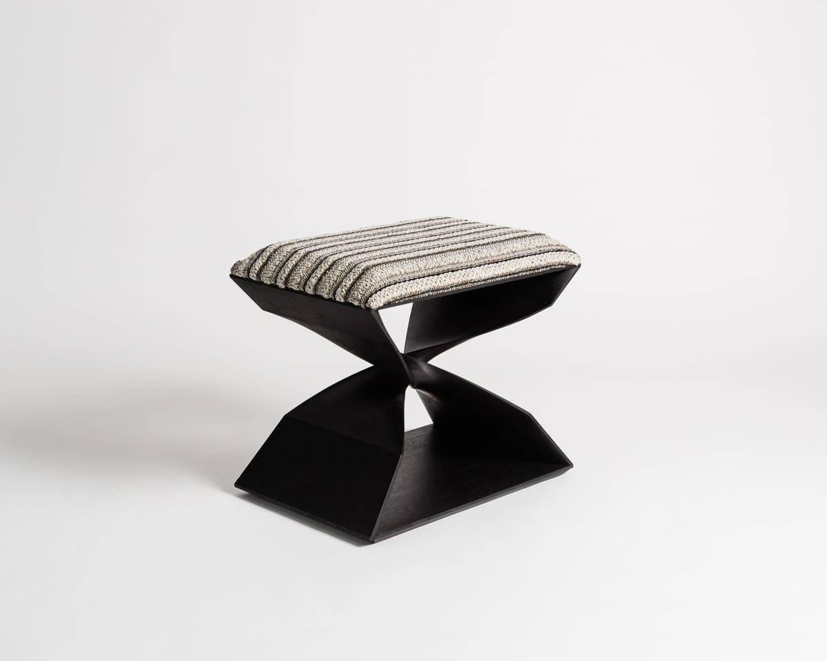 This sculptural hand-carved stool is part of a line of contemporary furniture designed by blending digital technology with fine traditional craftsmanship. Carved of ebonized sapele, the stool features two crisscrossing buttresses, which, twisting