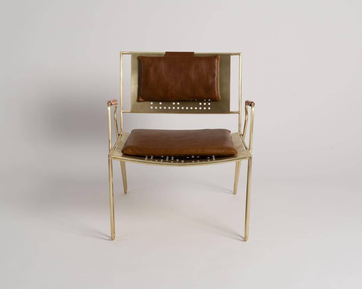 This dynamic, modern lounge chair, which can be used indoors or out, features removable leather pads, coiled copper armrests, and perforations in both the seat and back of its brushed bronze frame.
       