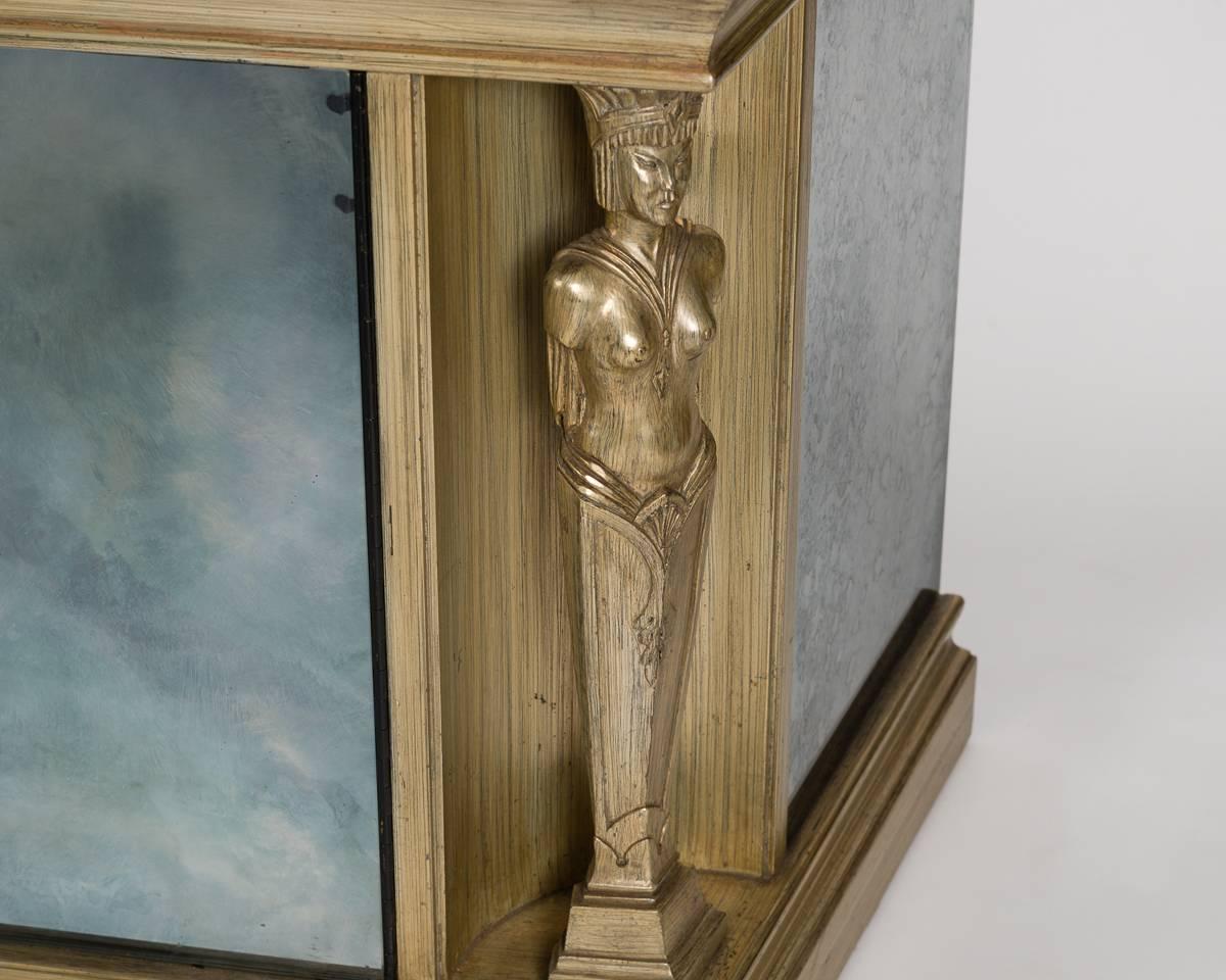 This remarkable cabinet, with its silvered wood, antique mirrored glass, and caryatids, has the signature aesthetic of the notable midcentury designer.