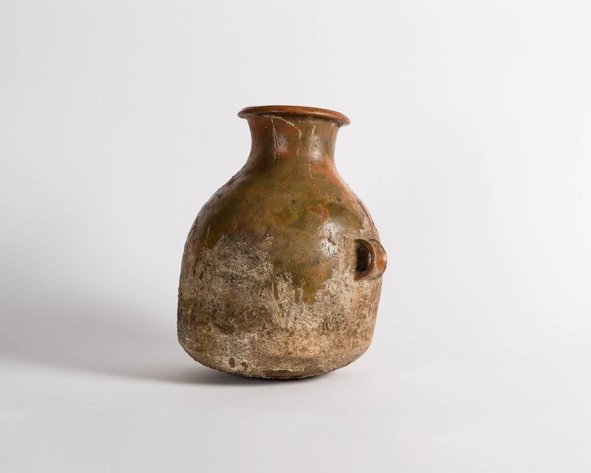One of several ancient vessels, dating from the Bronze Age, once held in famed designer Liz Claiborne's private collection, this piece features a flared rim, and two small, well-proportioned handles.