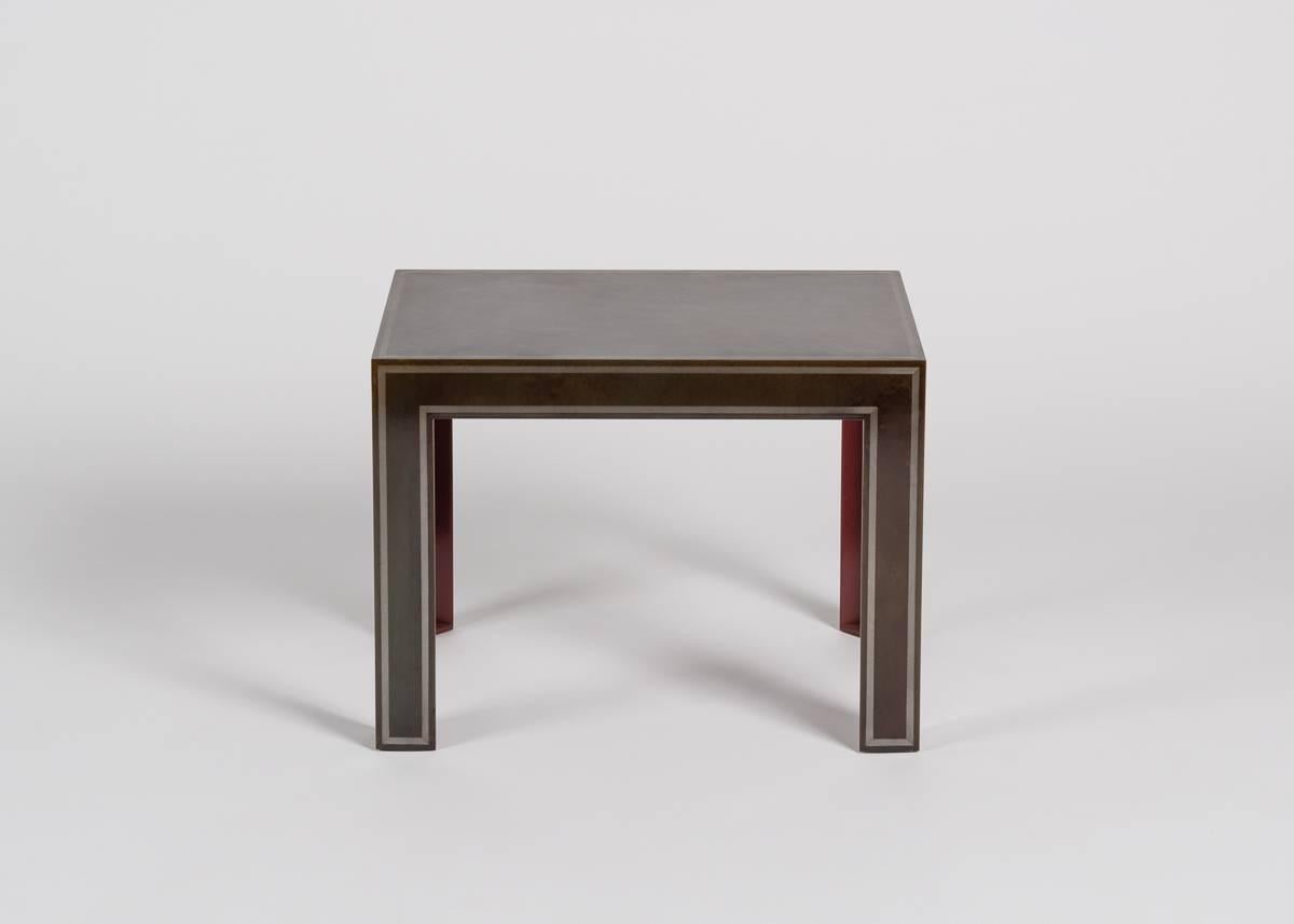 A side table in patinated steel with a light border accent by Baltimore based artists Alexandr Zhikulin.
