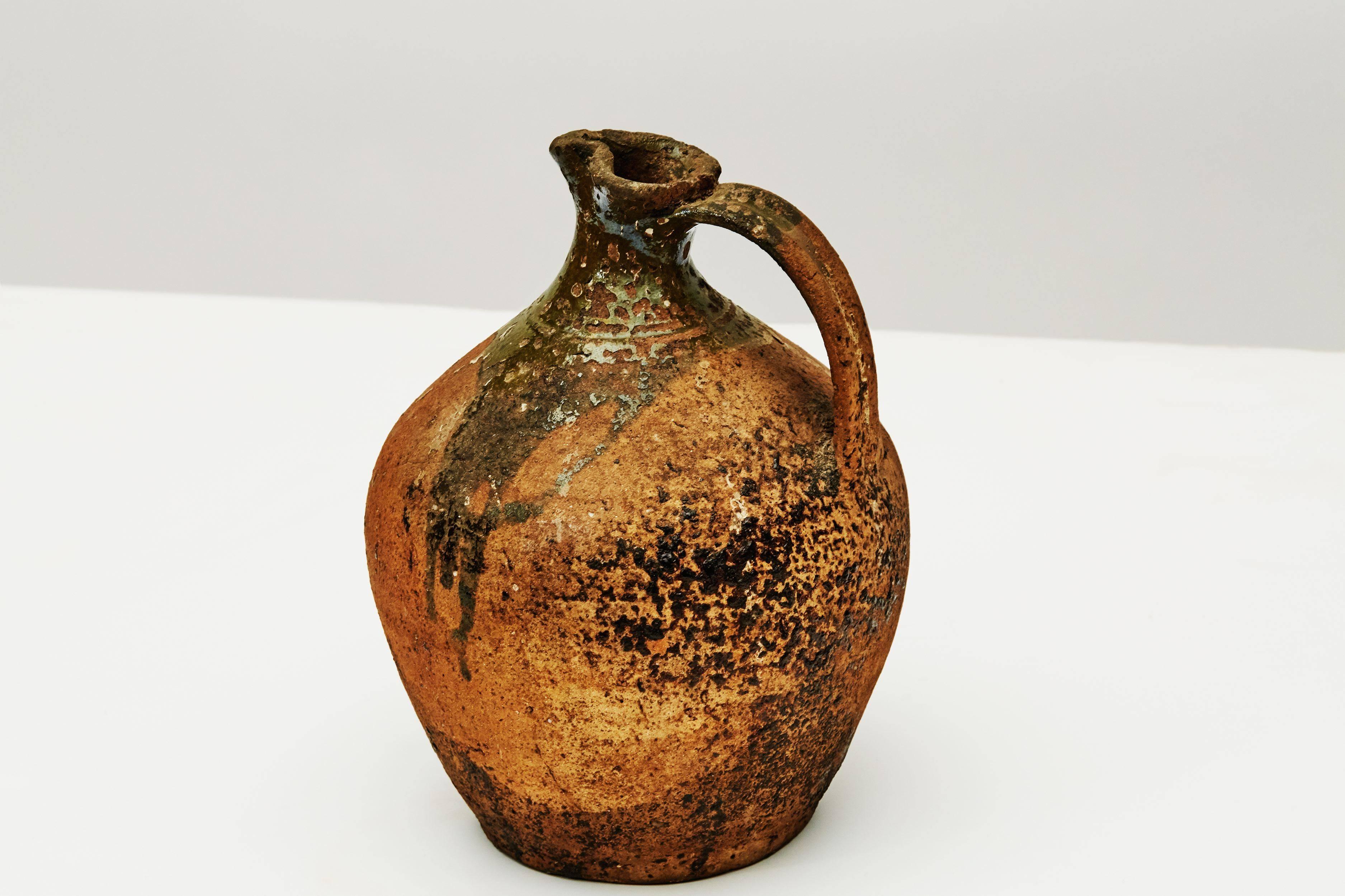 A ceramic jug hailing from Central Europe, and created in the mid-19th century, this piece, which was once held in famed designer Liz Claiborne's private collection, has an elegantly thin handle and a splayed lip, and has, moreover, been colored