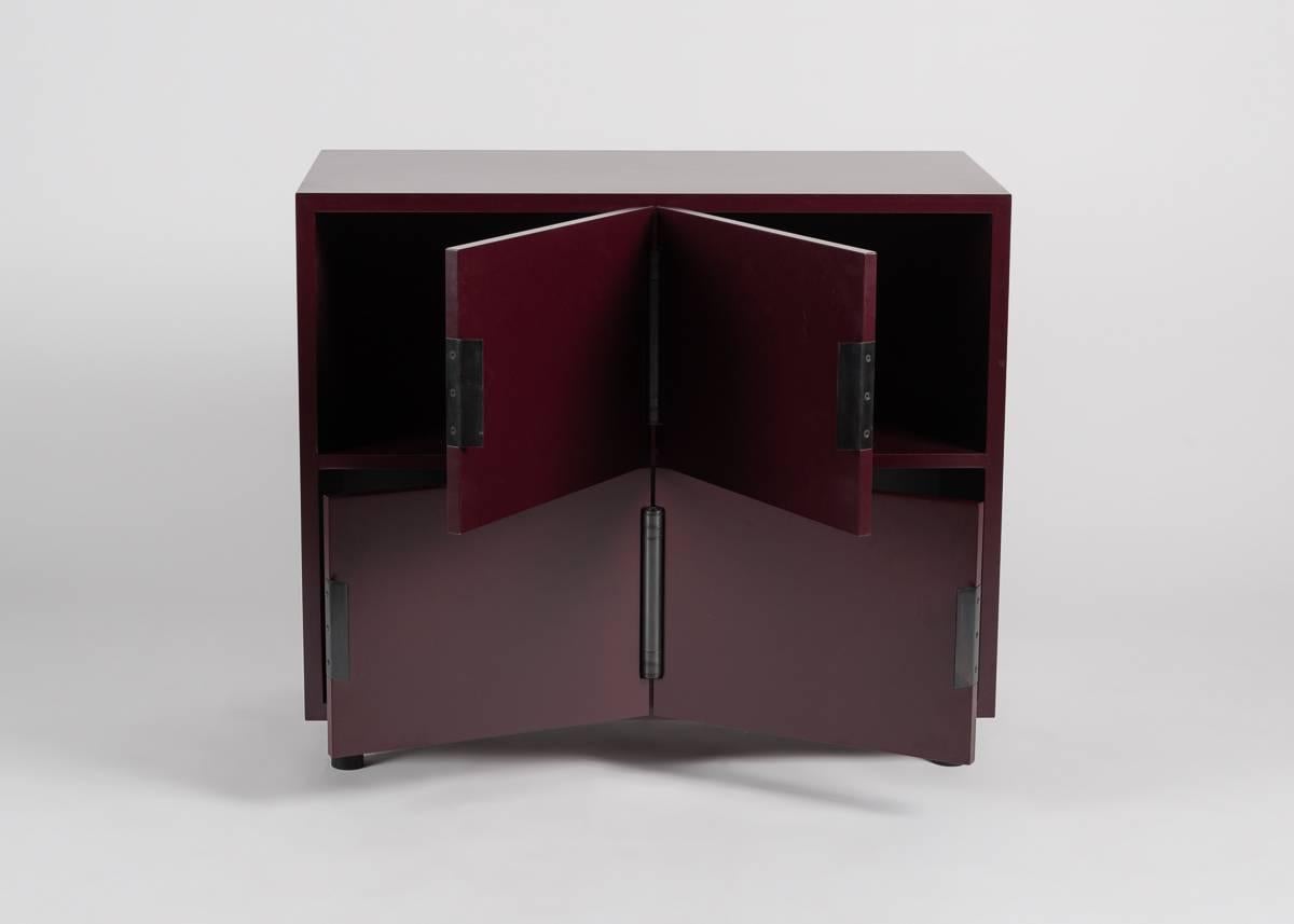 A sturdy, low, four-door cabinet in a rich ox-blood lacquer, by Brooklyn based Mat Driscoll.