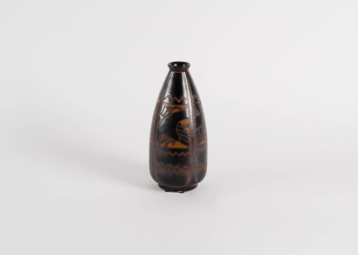 Diese Vase trägt die Nummer D.1009 von Catteau und zeigt Vögel vor stilisiertem Blattwerk, das auf Feldern mit ausgeprägt geometrischen Formen ruht. Die physische Form der Vase unterscheidet sich von einigen anderen Produktionen Catteaus mit dieser