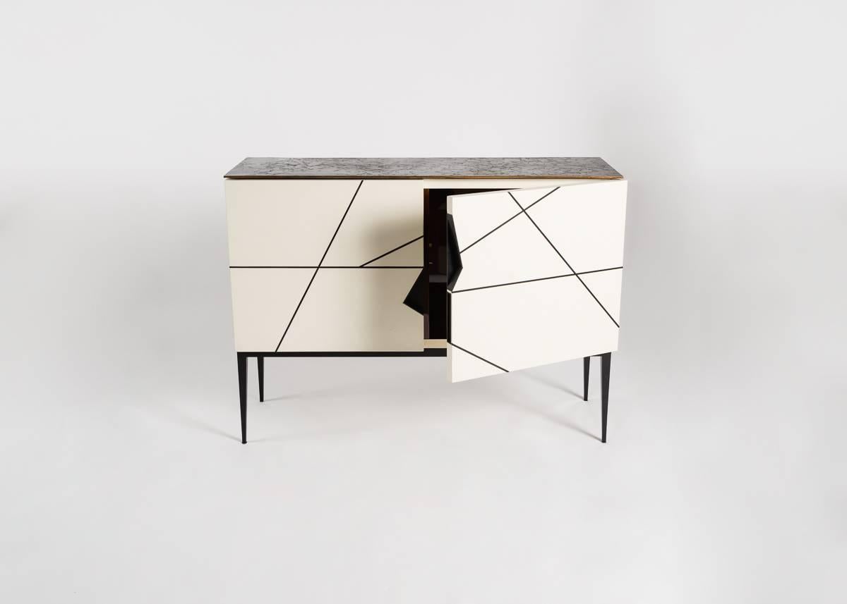Custom double-door bar cabinet by Achille Salvagni.
Bianco Opaco parchment exterior, oak interior, glass shelves, dark bronze top and inlay.
Limited edition of six.
Stamped: Achille Salvagni Atelier.
