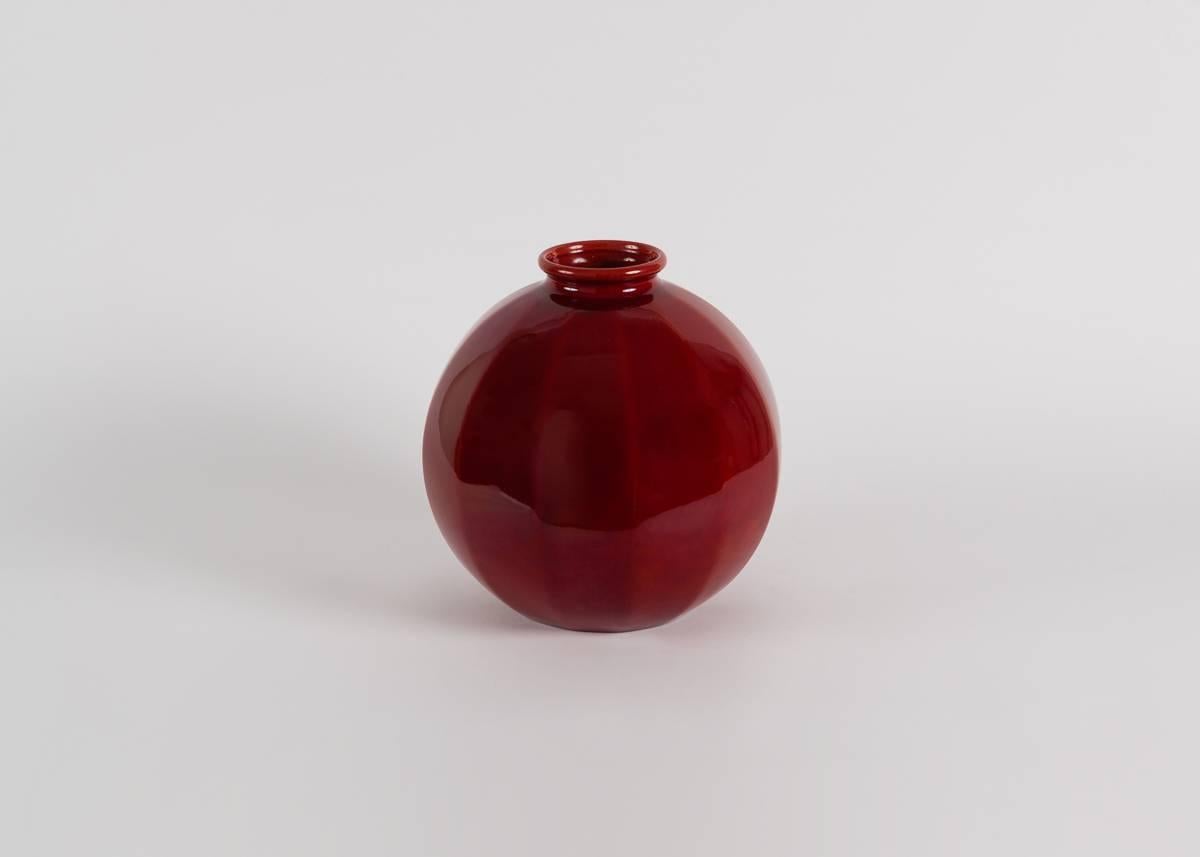 This spherical vase with longitudinal accents has a rich oxblood glaze, and a petite, round rim.

Stamped: PM Sèvres.