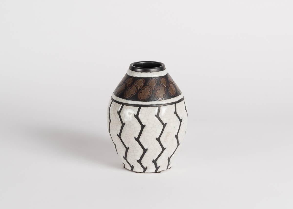 This vase features a different take on the floral motif. Using design number D.776, Catteau here presents sharp, forbidding lines cutting through the white glaze, giving life to the more colorful seedbed at the top.

Marked: Ch. CATTEAU Grès
