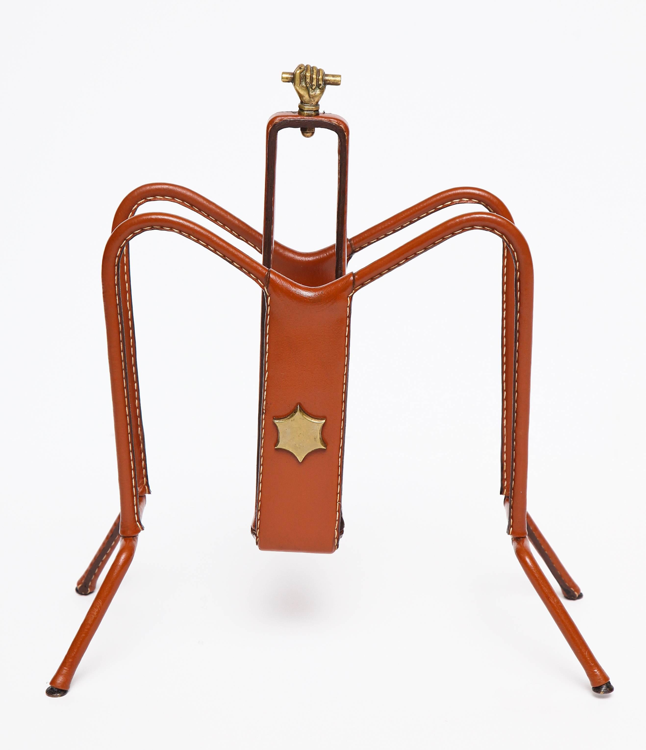 Leather and metal magazine rack by Perrier & Fils.
wrought iron, copper star and handle.

Please note that the leather stitched wrapping covering the wrought iron frame is a recent addition.

We thank Docantic for their help in providing us