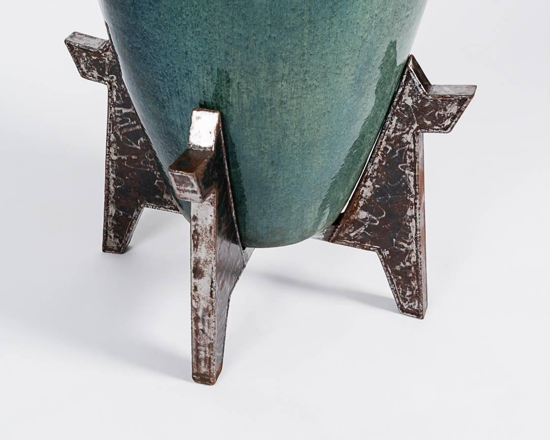 Monumental glazed ceramic urn on welded steel base. Available as a pair.
  