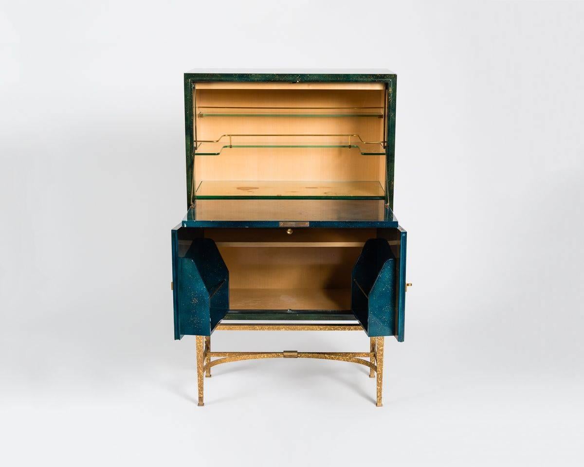Lacquered wood and gilt bronze bar cabinet, in the manner of Jacques Adnet and Gilbert Poillerat.
