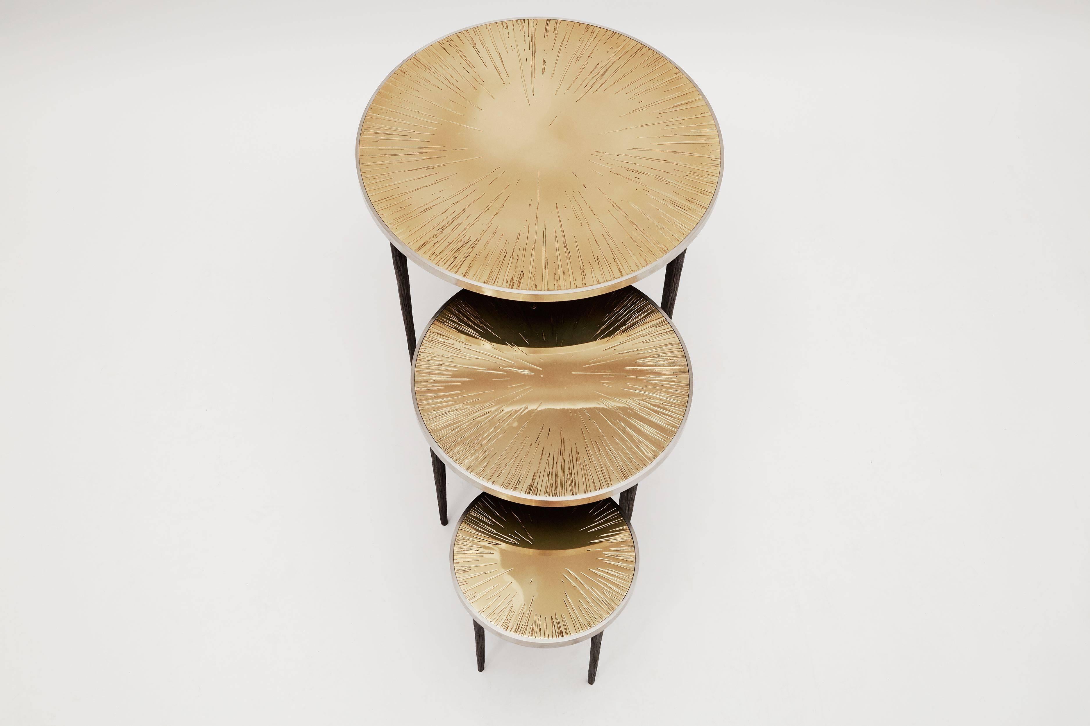 A set of three nesting tables in polished bronze and steel.

Franck Chartrain, born in 1971, is a French artist, furniture designer, and expert metalsmith. His work, known all over the world, is as consistently innovative as it is resolutely in