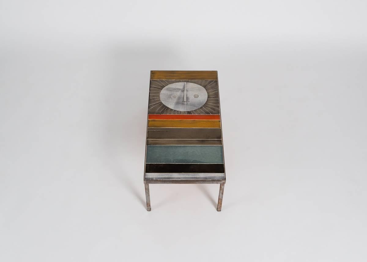 A coffee table by the great French designer Roger Capron, featuring bands of color and an abstraction of a radiant sun.