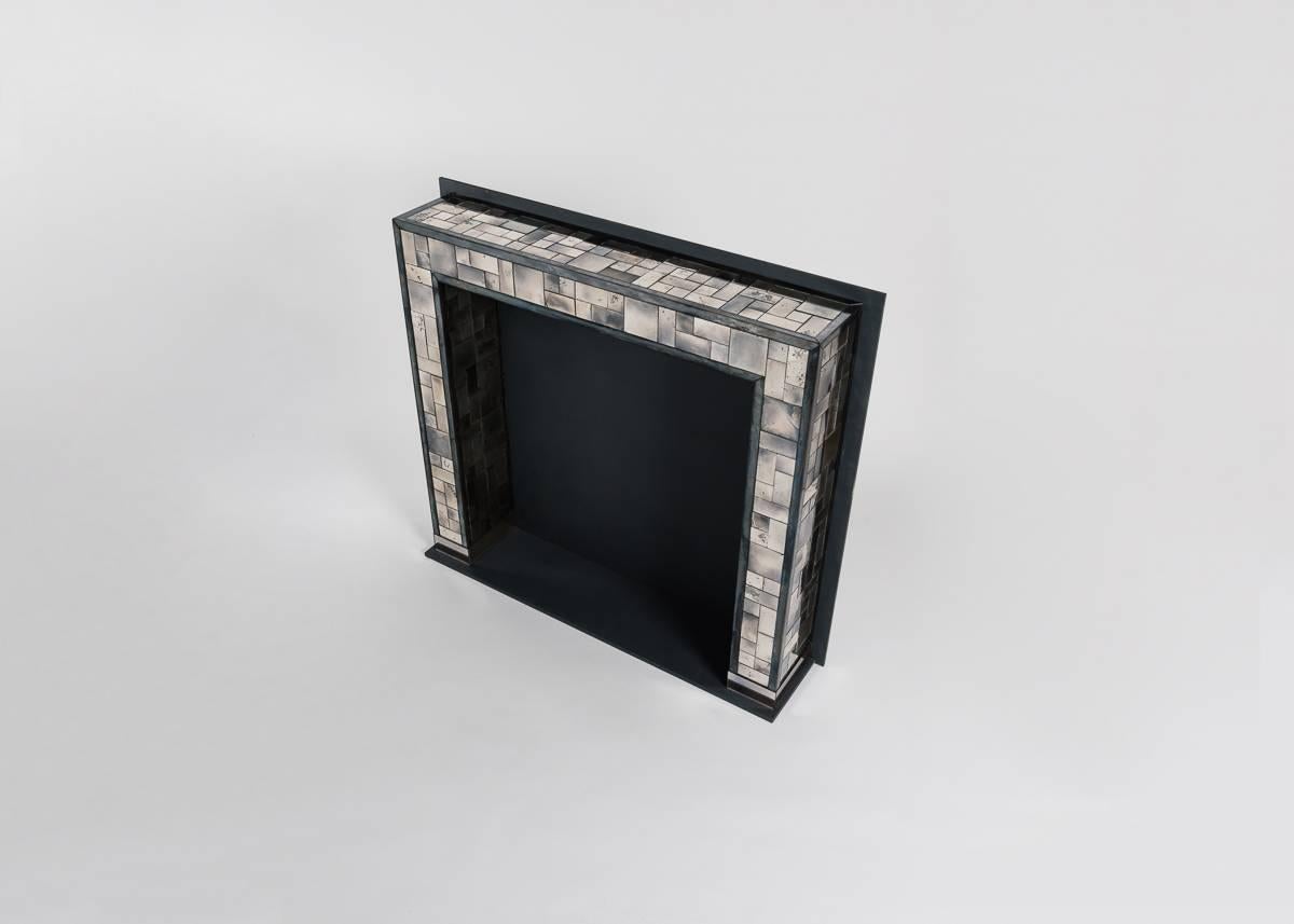Kiko Lopez is one of the few artisans working today in the traditional craft of hand-silvering. In this piece, Lopez applies the technique to a unique background--that of a fireplace surround. The mirrored panels reflect and absorb the warm colors
