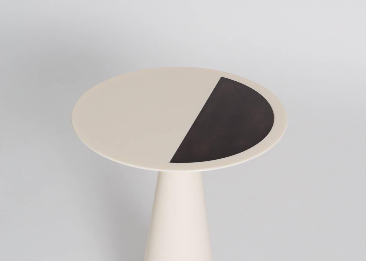 This set of nesting occasional tables, made of a silky smooth, laminated Corian, play with the contrast of night with day, of light with darkness. The pieces are entirely black and white and adorned with intricate, laser cut and bronze inlaid
