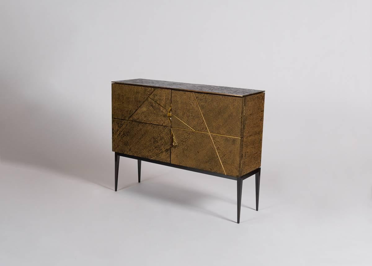 Giò is a double-door cabinet of lacewood with a burnished cast bronze top, 24-karat gold-plated and polished accents, inset cast-bronze handles, and polished brass inset details. An homage to the Italian designer’s predecessor Gio Ponti, the cabinet