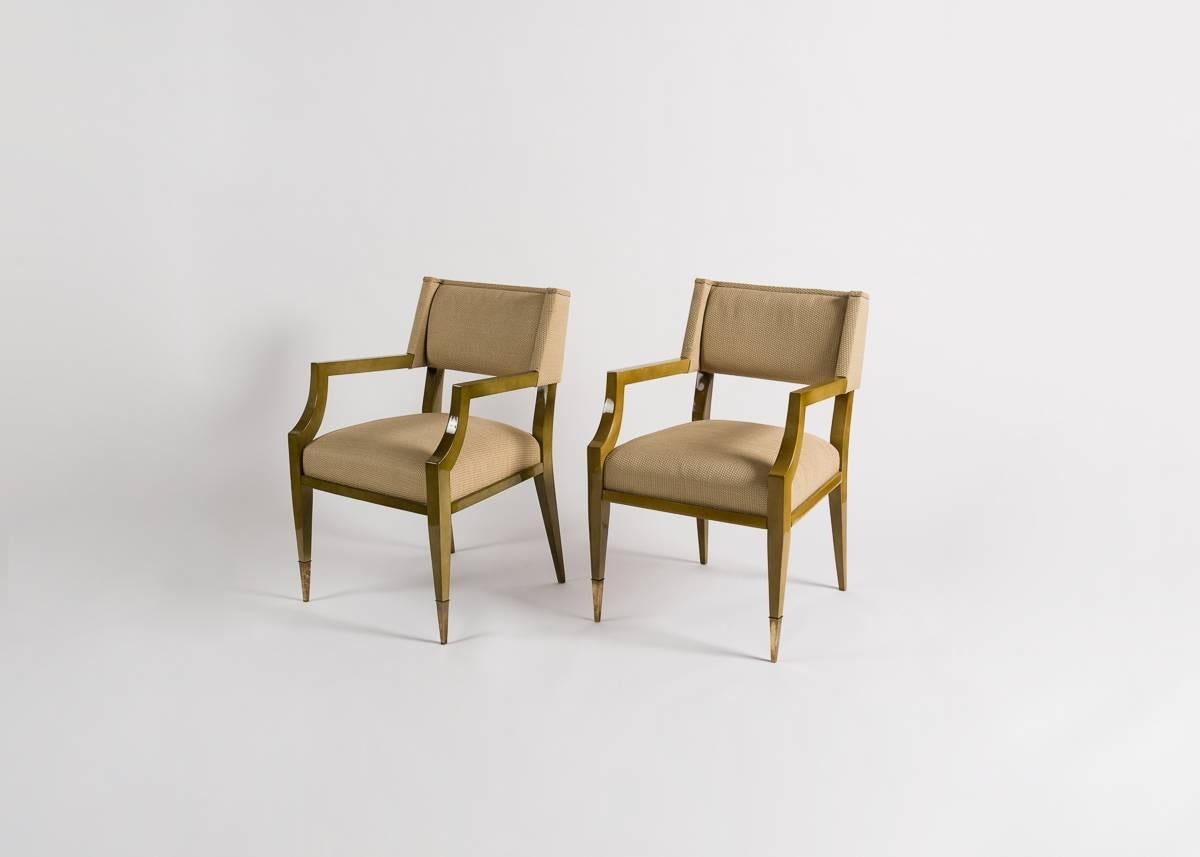 This pair of elegant armchairs attributed to the noted French designer Raphael feature subtly winged backs, tapered legs, and sabots.