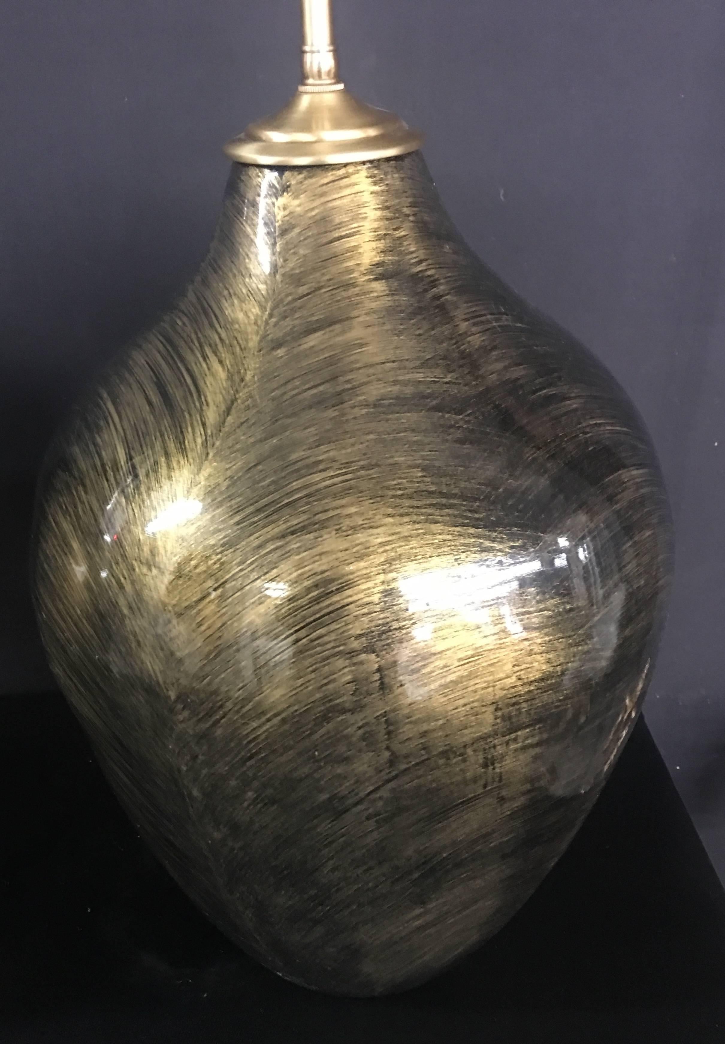 Pair of gold and black glazed orbs with lamp application, the lamps are newly wired. The hardware is brushed brass, the dual sockets are individually controlled. The vessel height is 18