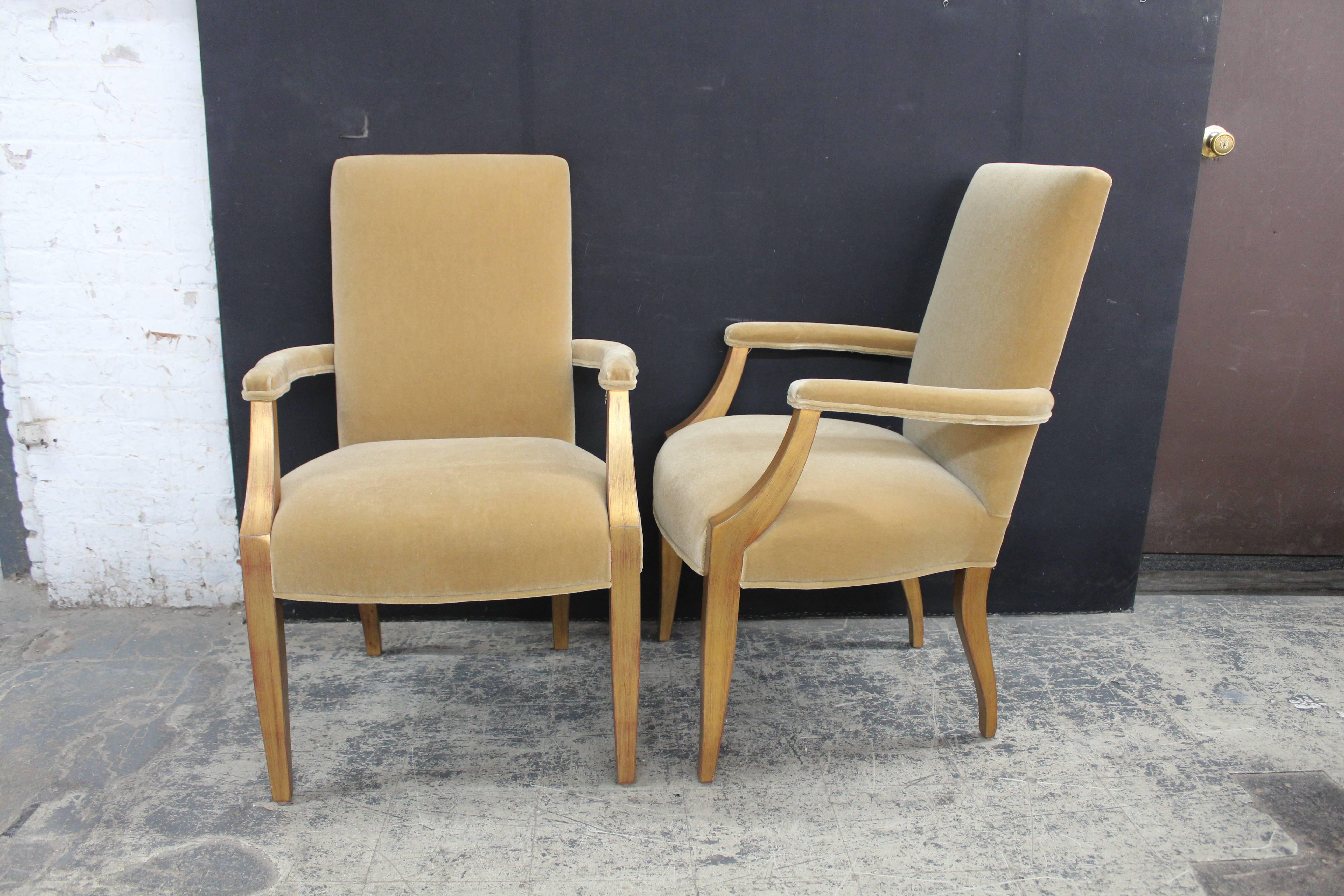 A pair of giltwood open armchairs in the manner of Andre Arbus. The chairs are upholstered in a rich golden Mohair on the seat, seat back and arms. The outside back is in a striped velvet. The gilded finish is a wash allowing the gesso to show