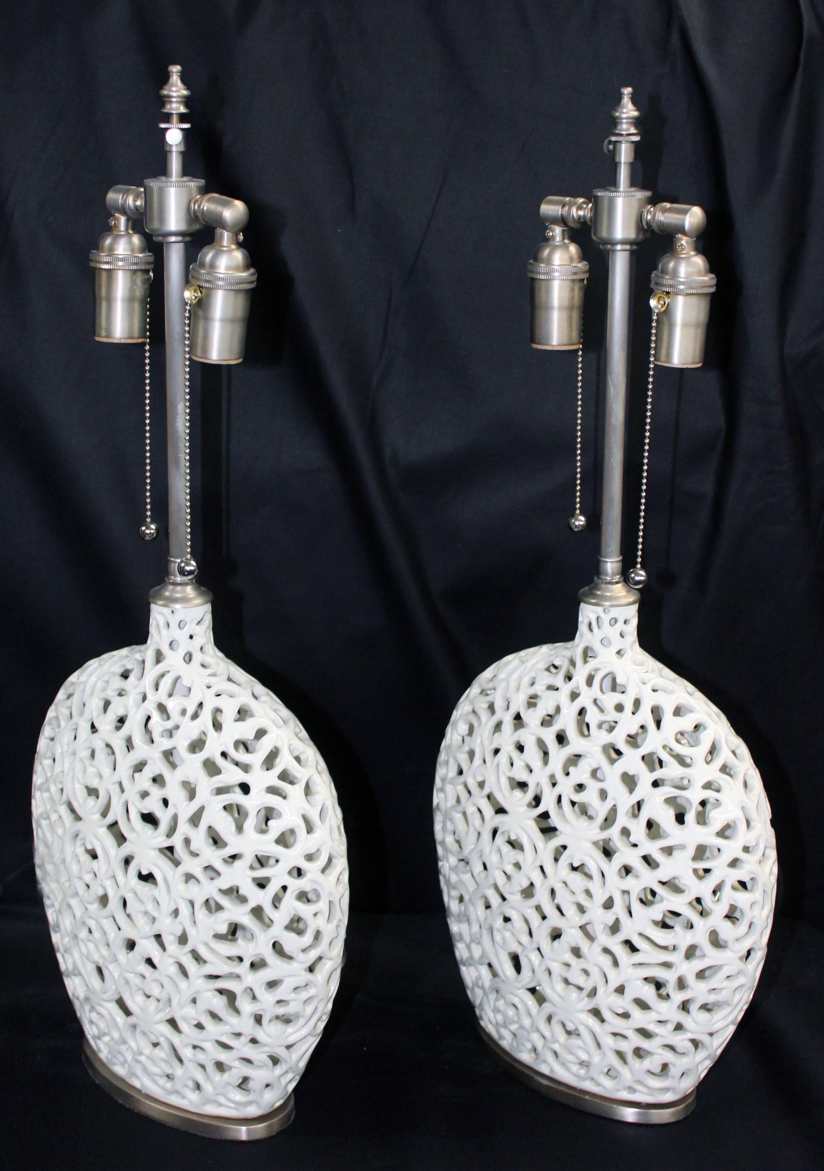 Unusual pair of cream colored ceramic filigree vessels with lamp application. The vessels are newly wired with Dual control chains. The vessel height is 13