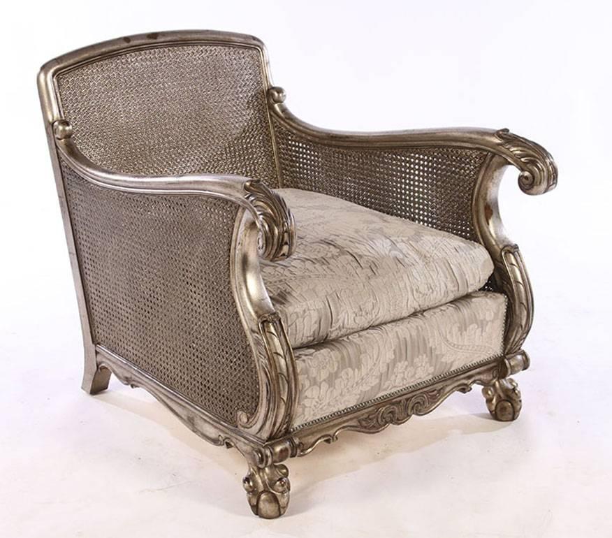 Pair of carved and silver gilt chairs having caned backs and sides with acanthus and scroll decoration. All raised on ball and claw feet.
