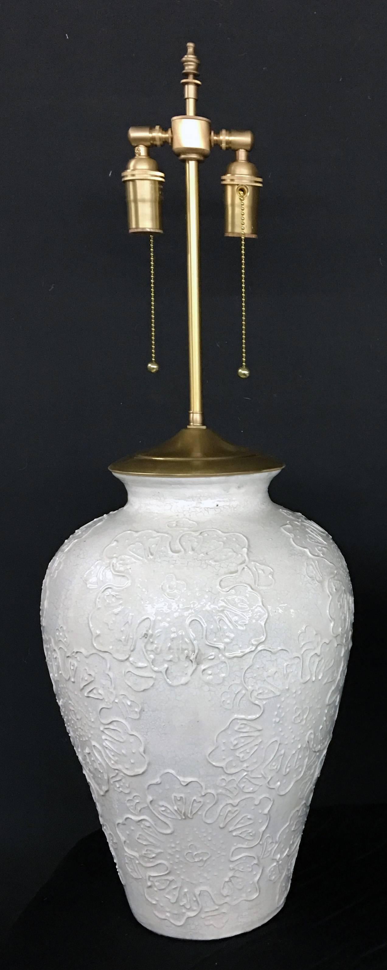 Pair of large nicely detailed glazed pottery urns with lamp application. The lamps are newly wired. The hardware is brushed Brass with individually controlled dual sockets. The urns are 18