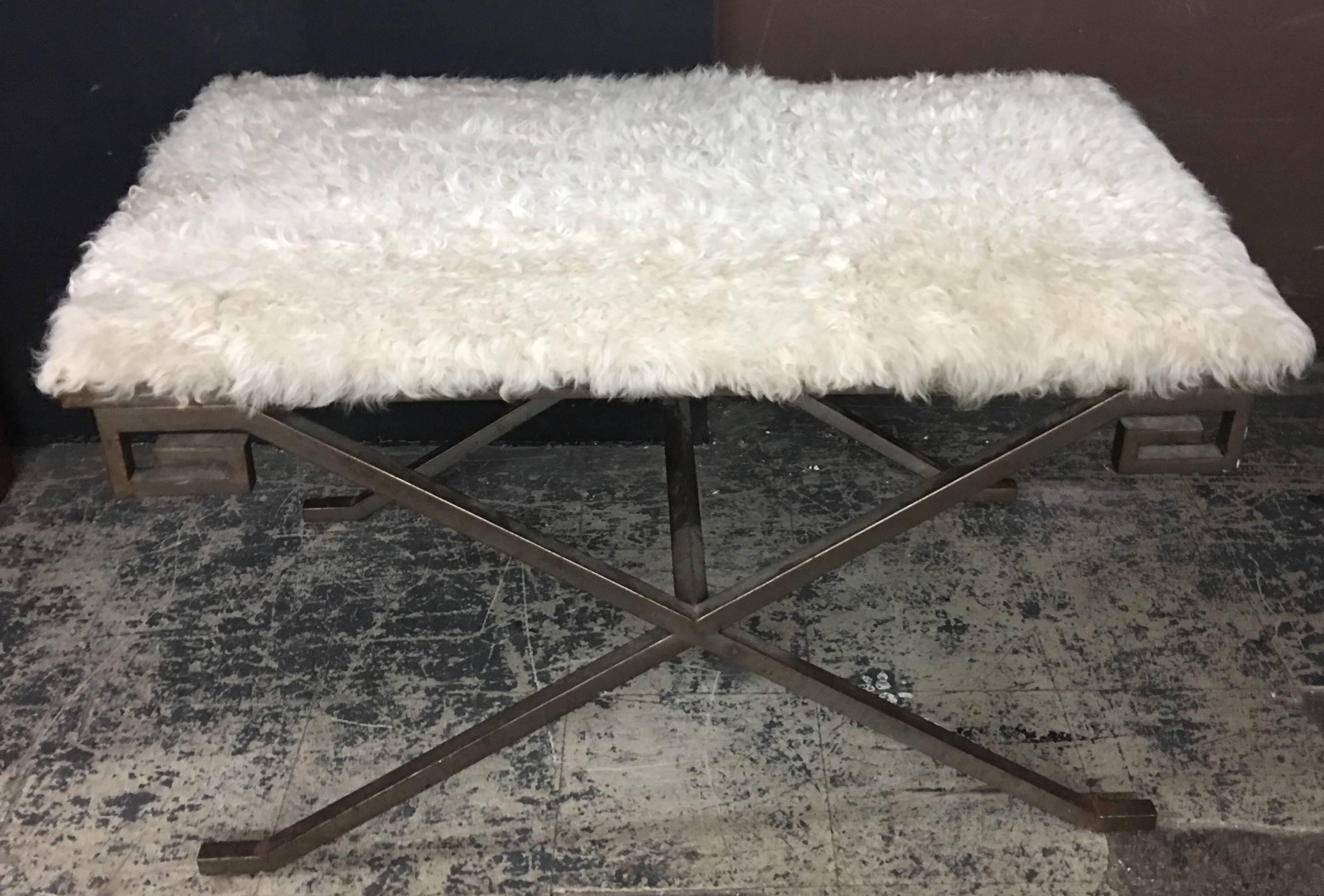 Hollywood Regency style bench with a faux fur seat and Greek key corner detail. The base is patinated steel.