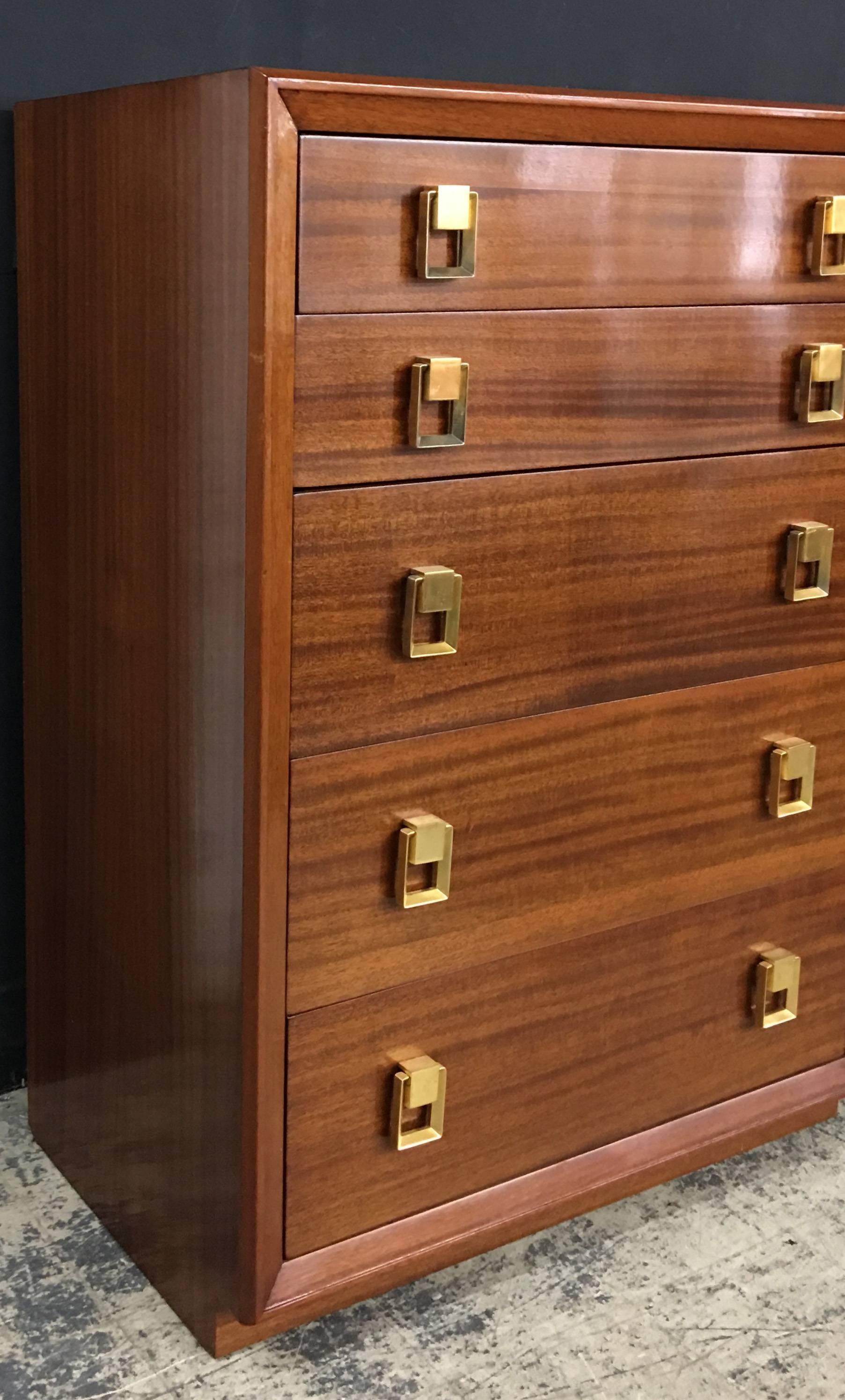 Mid-Century Gilbert Rohde tall chest in mahogany with five graduating drawers and large brass pulls. Measure: The top two drawers are 5.5