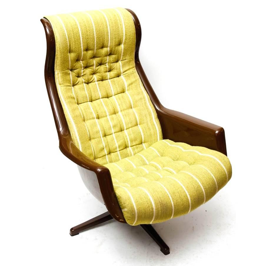A 1970s Galaxy chair designed by Alf Svensson for DUX. This chairs features an upholstered and tufted yellow-green cushion with white stripes, a mahogany colored plastic frame and pedestal base. One of the most comfortable ergonomic chairs we've