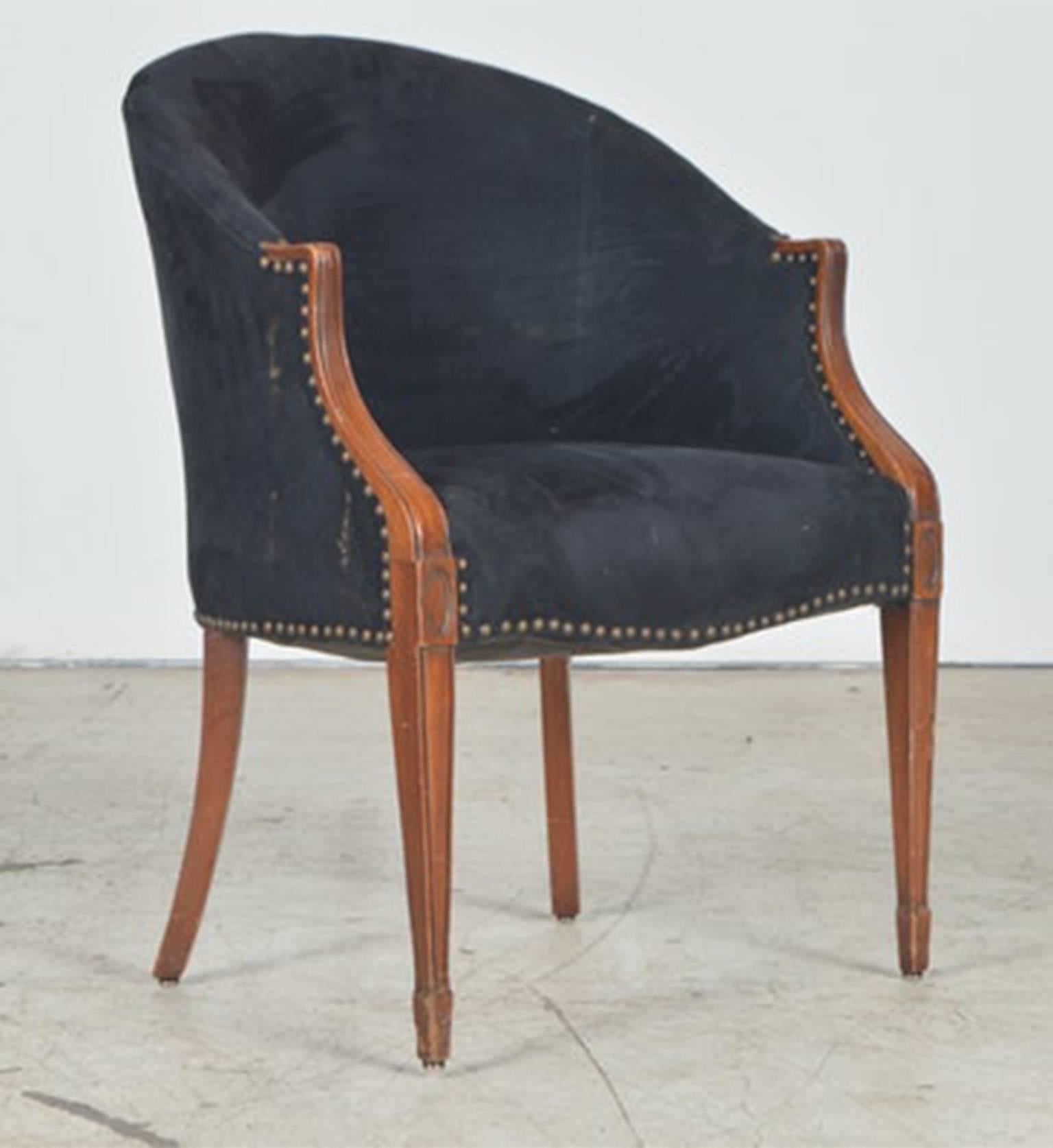 A set of 4 vintage barrel back chairs. Neoclassical in form the chairs have a high rounded back and piece arms. The back and the sides of the chairs are covered in black velveteen fabric with exposed brass nailheads along the arms and seat of the