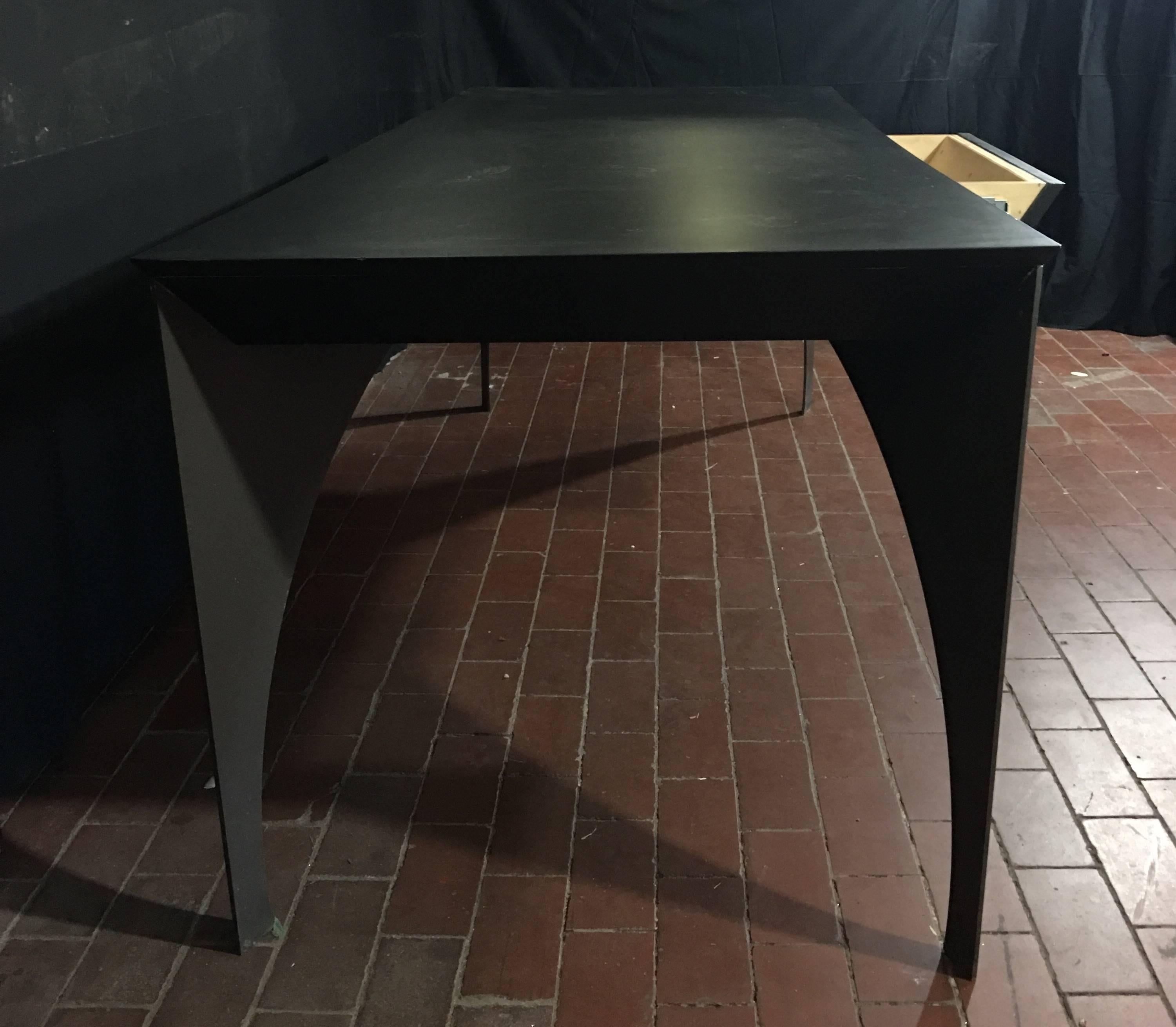 Custom one-of-a-kind table or desk in steel and lacquered wood. The steel arched legs are finished in a satin gun metal gray, the mitered edge, solid wood top is lacquered in a flat black finish. The table contains a single drawer the is 26