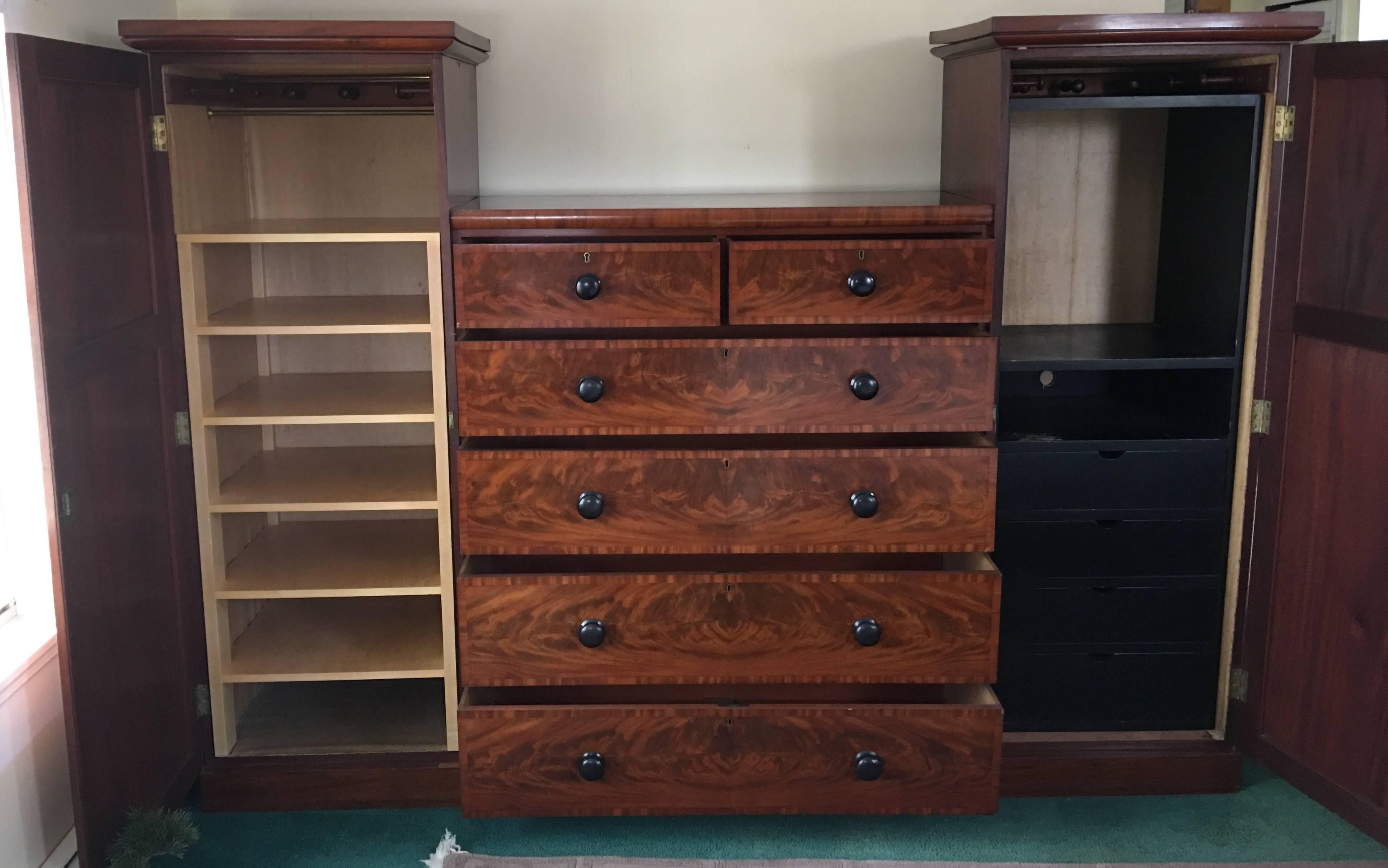 This beautiful mid-19th century English flamed mahogany dresser and wardrobe combination was outfitted with shelving on one side and drawers and space for a small TV on the other (both can be removed) the cabinets flanking the large six-drawer chest
