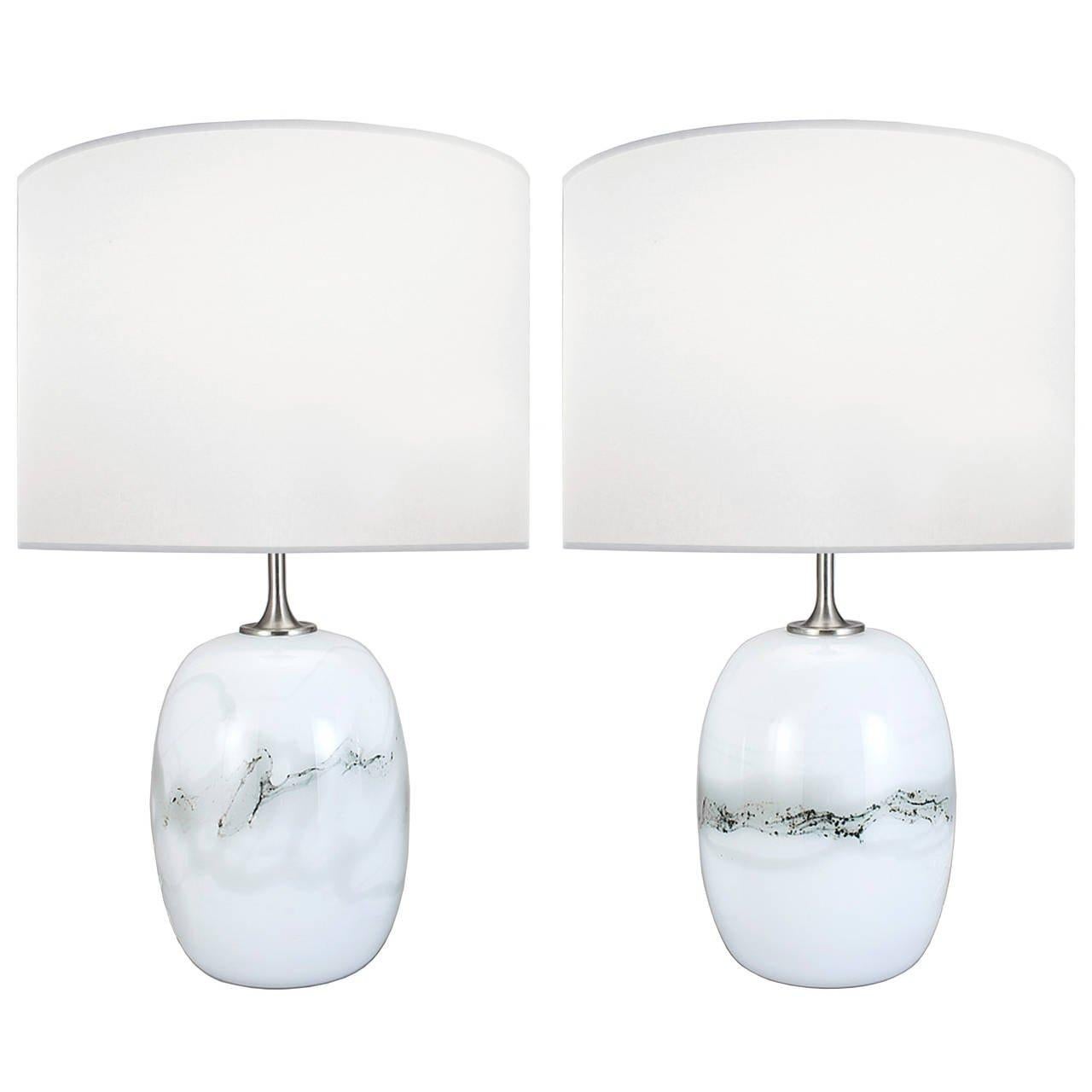A pair of white glass lamps with gray modeling and nickel hardware by Holmegaard.

Denmark, Circa 1960's

Lamp Shades Are Not Included.

If you are interested in Lamp Shades, please email The Craig Van Den Brulle Design Team Via Message Center, and