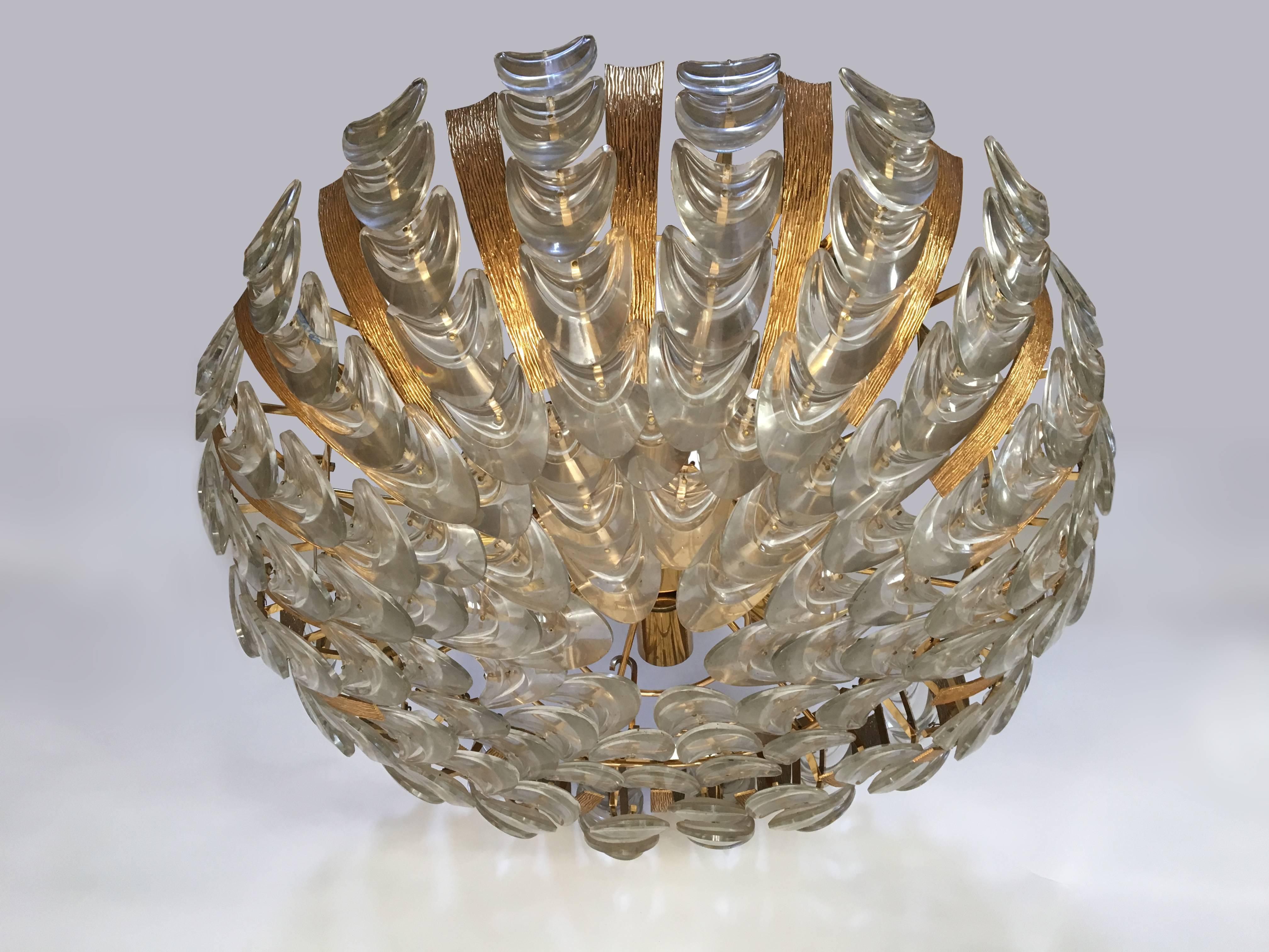 A gilt textured brass chandelier with multiple pieces of glass.

Austrian, Circa 1960's


 