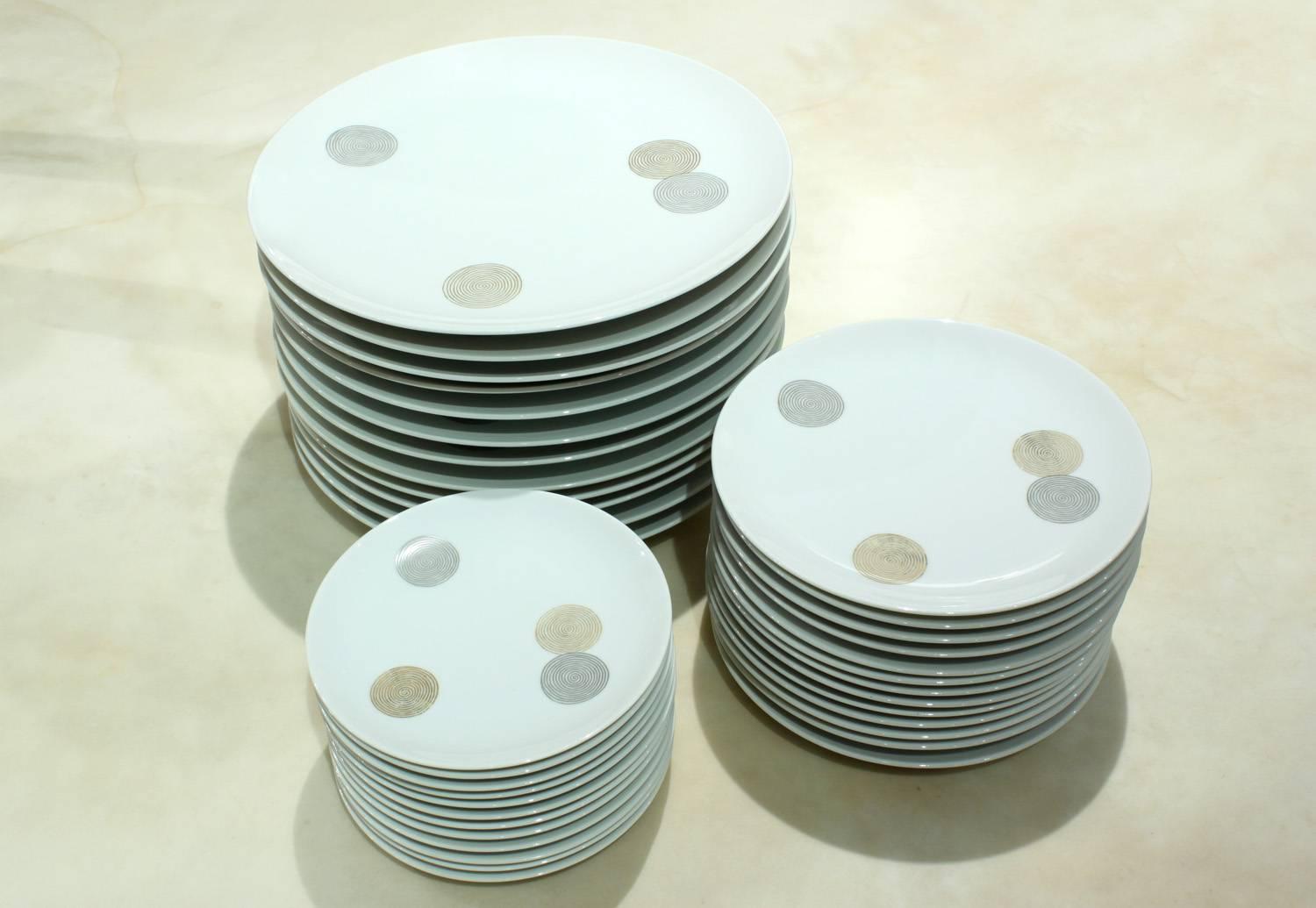 Fine dinnerware service for 12 with concentric circle design in gold and silver by Raymond Loewy for Continental China, Germany, 1950s (signed on bottom).
This is a rare and beautiful china service by one of the best Mid-Century