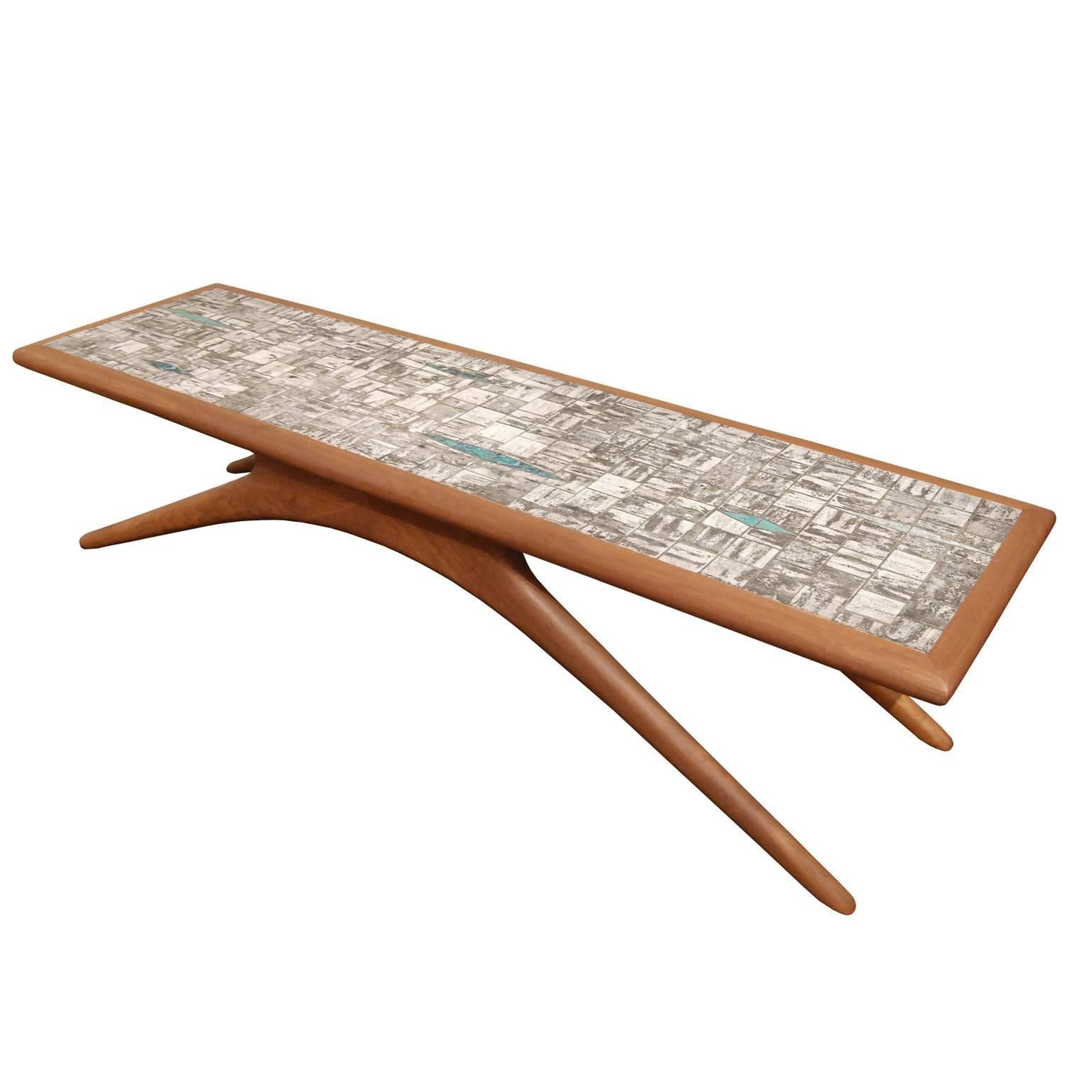Sculptural coffee table in walnut with inset handmade ceramic tiles and splayed legs in the manner of Vladamir Kagan, American, 1950s.
 