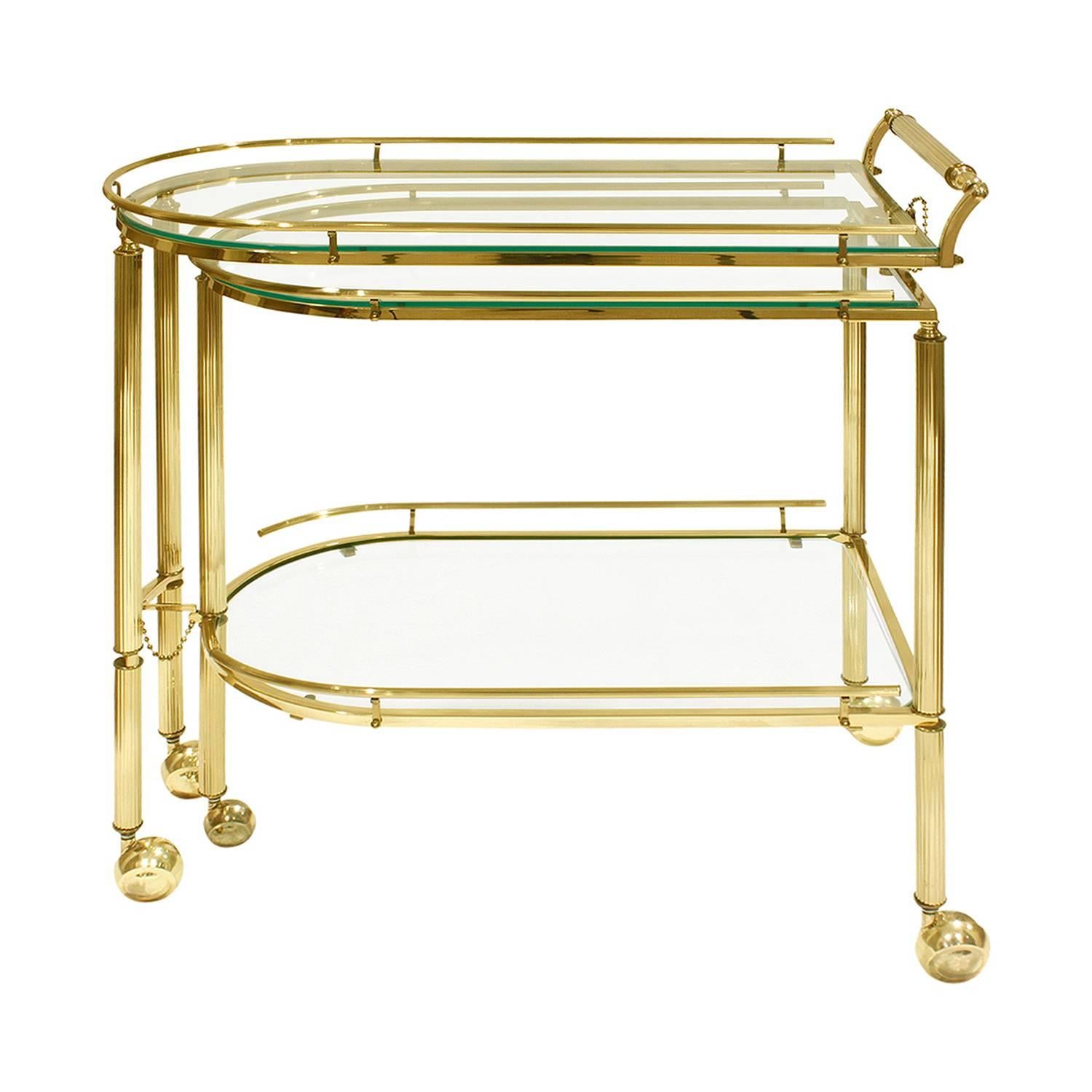 Expandable rolling serving cart in channelled brass with glass shelves attributed to Mastercraft, American, 1960s. This is a clever design which provides a lot of serving space.

Cart is 54 inches long when fully extended.