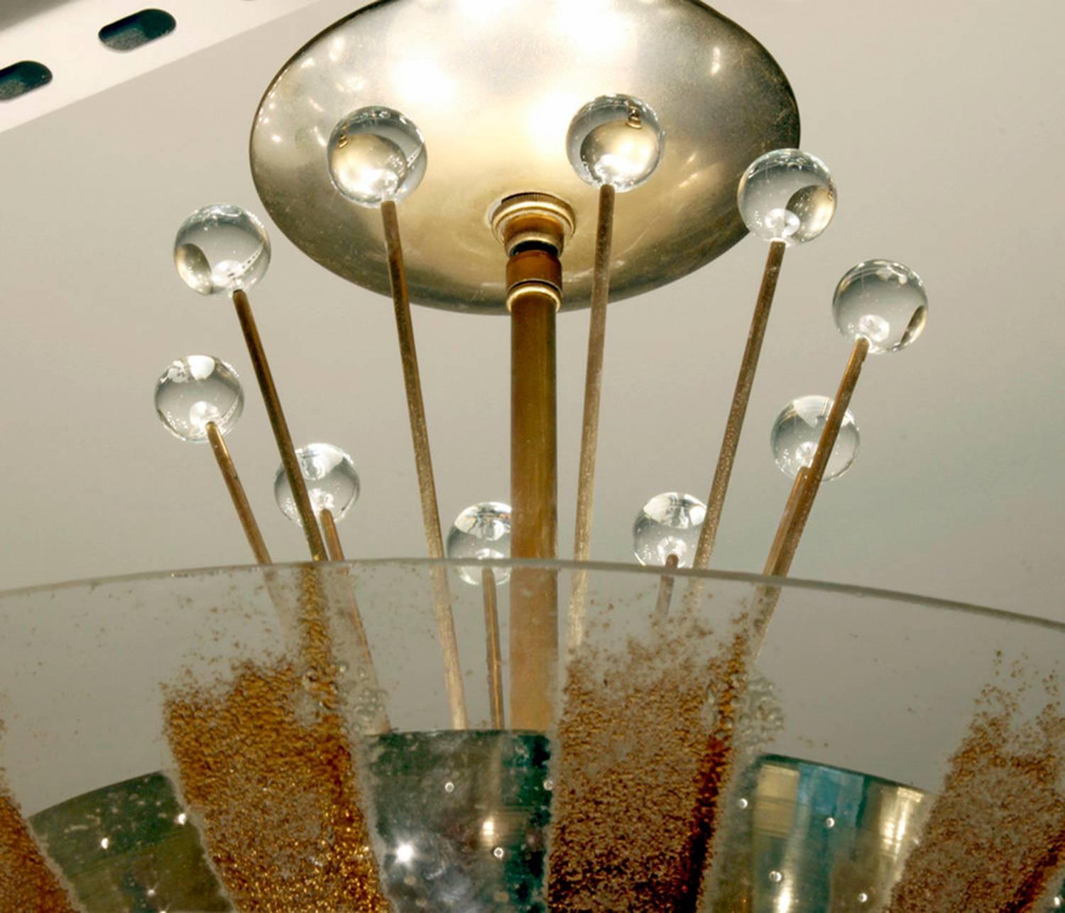 Ceiling mount fixture in brass with perforated shade, glass shade with radiating gold pattern, and crystal spheres by Gerald Thurston for Lightolier, American, 1960s.