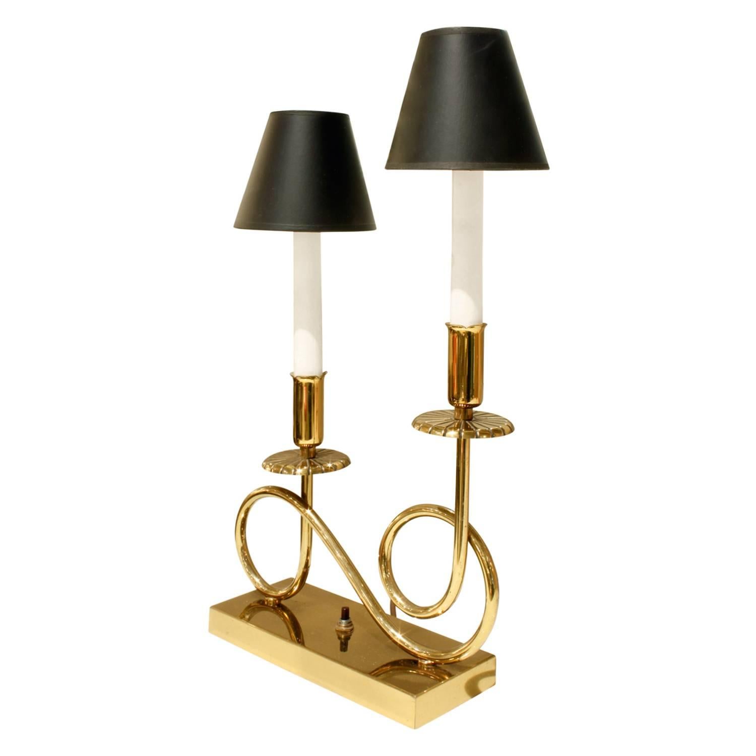 Pair of elegant brass table lamps, each with two lights, in the style of Tommi Parzinger, American, 1950s

Table lamps are 11 inches wide and 4 inches deep with shades.