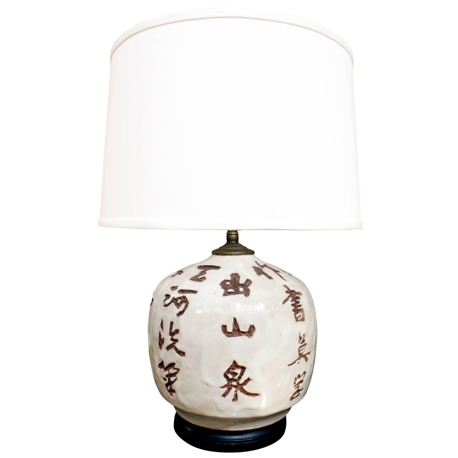 Pair of chic studio ceramic table lamps with Chinese character decoration with wooden bases, American, 1950s. These lamps are beautifully made.

Measures: Shade diameter 14 inches.