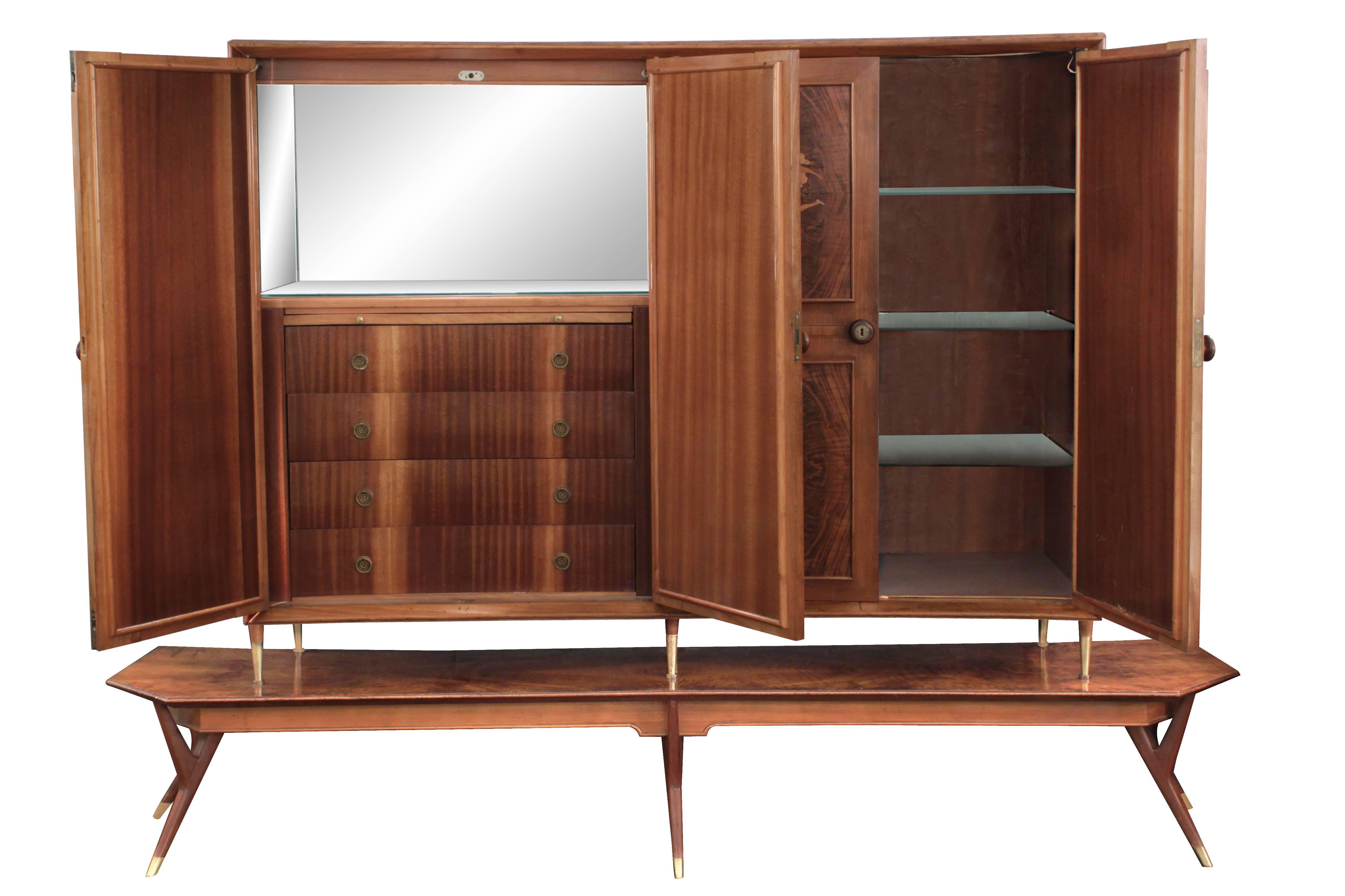 Four-door cabinet with exquisite figural inlays in exotic woods on sculptural base by Eugenio Diez, Buenos Aires, Argentina, 1940s. Each door has two raised and illuminated panels with inlays. The left side interior is an illuminated cabinet with