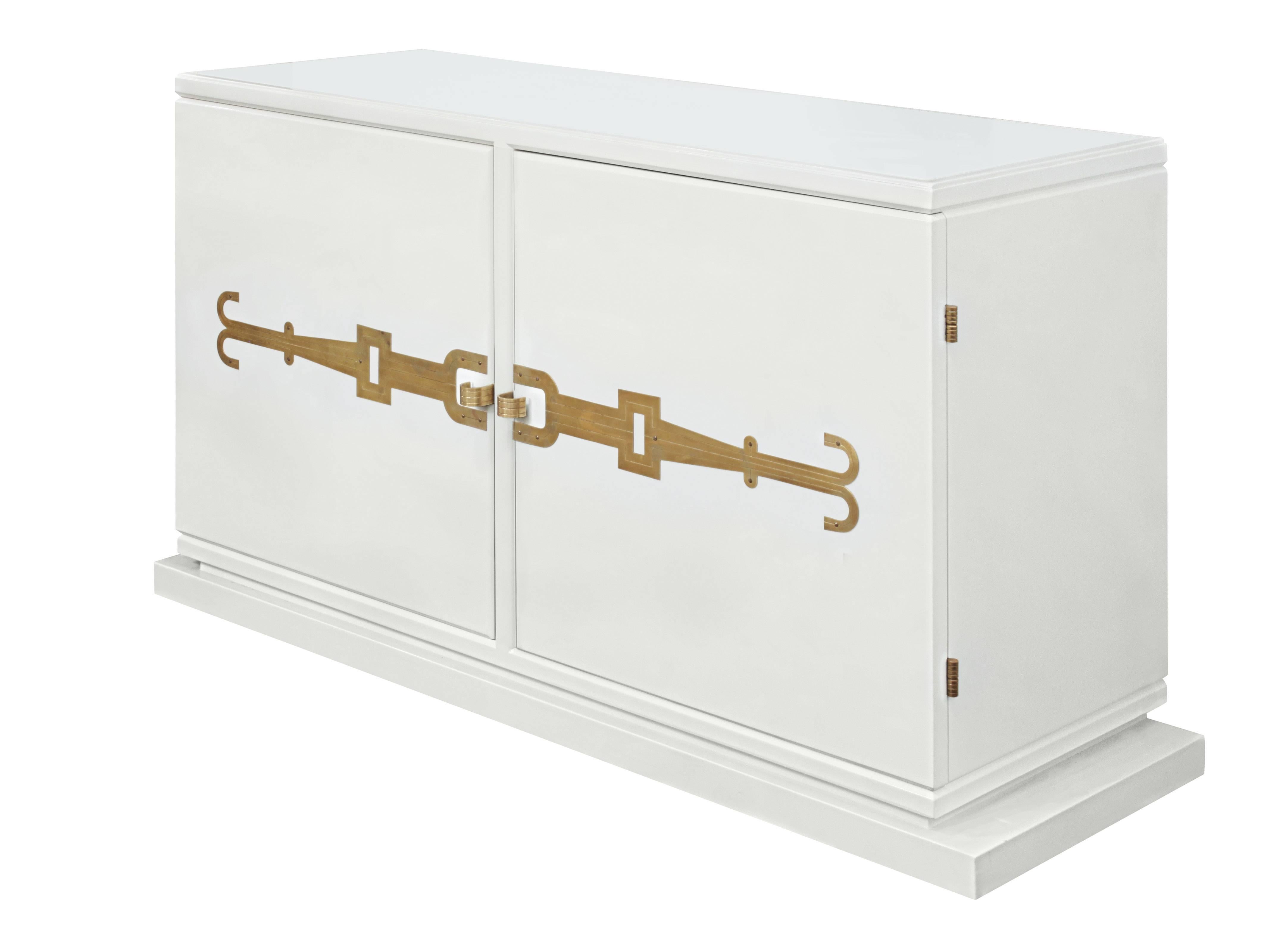 Fine and rare two-door credenza No. 140 in white lacquer with iconic brass hardware and inset white glass top by Tommi Parzinger for Parzinger Originals, American, 1950s.
 