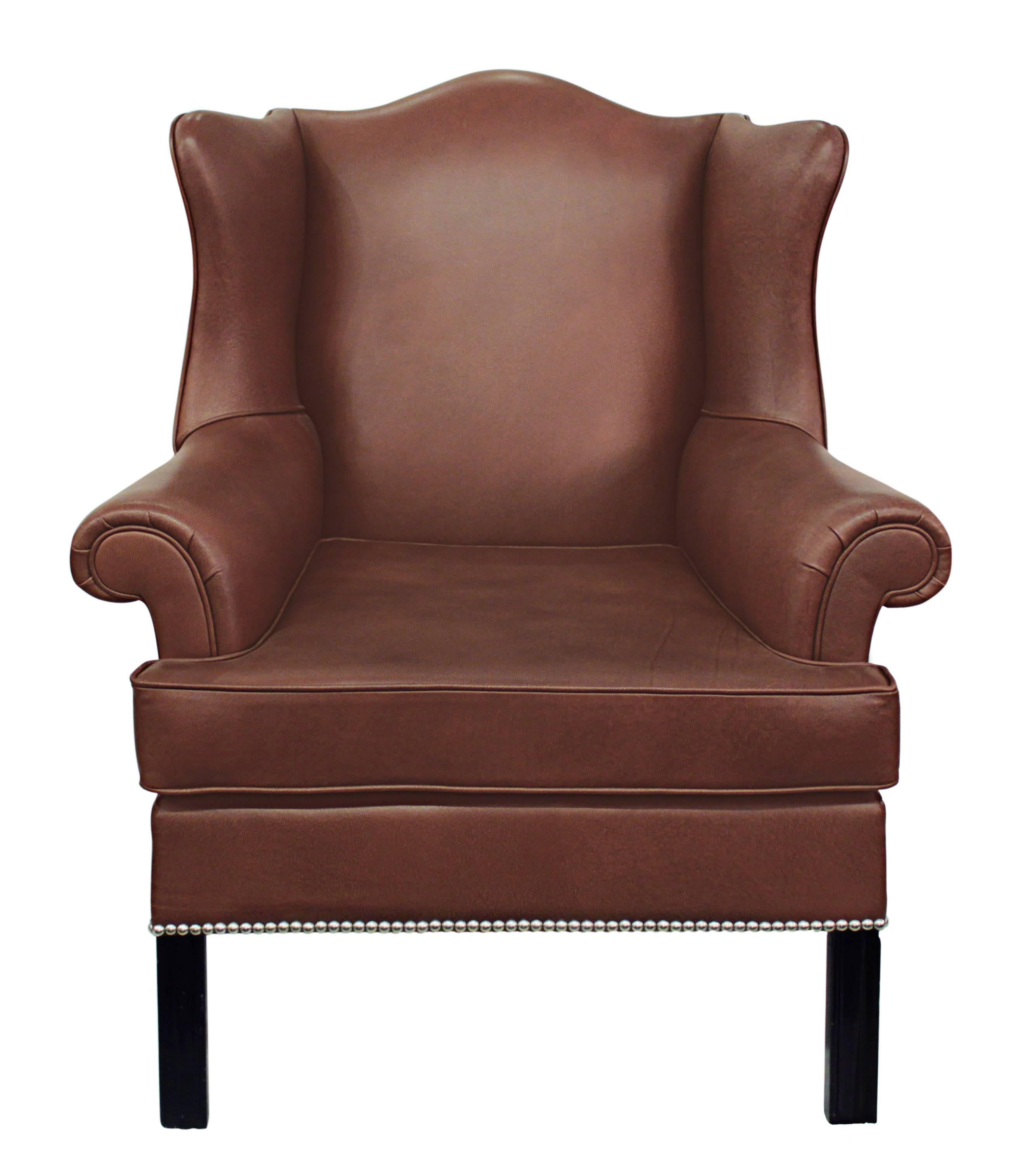Small-scale wing chair No. 1710B with base in mahogany designed by Edward Wormley for Dunbar, American, 1930s. Refinished and reupholstered in chocolate brown leather with nickel studs. (Original label sewn back into chair.) This is an early elegant