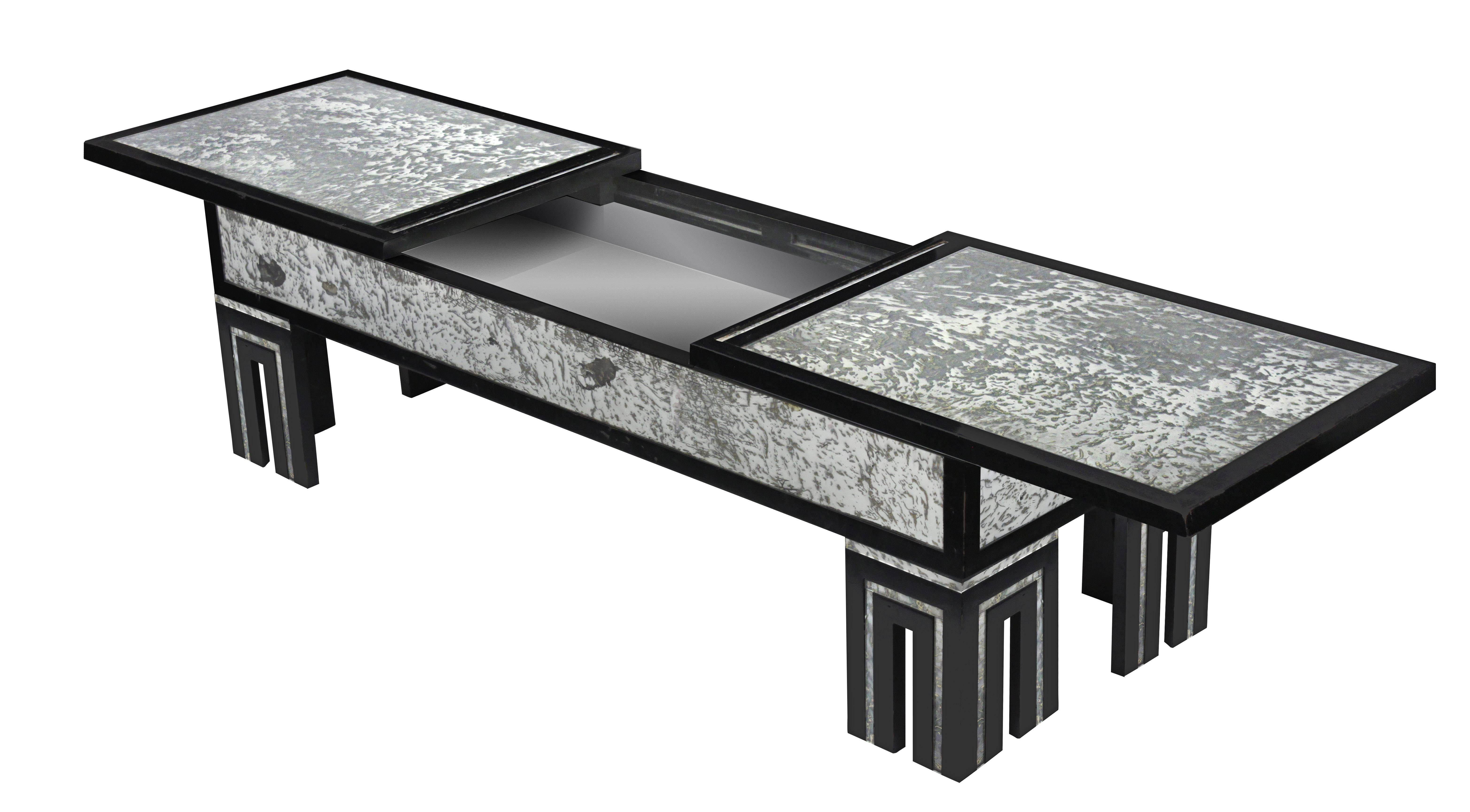 Ebonized coffee table with mottled antique glass and retractable top by James Mont, American, 1940s. Table is 68 inches wide when top is fully opened.
   