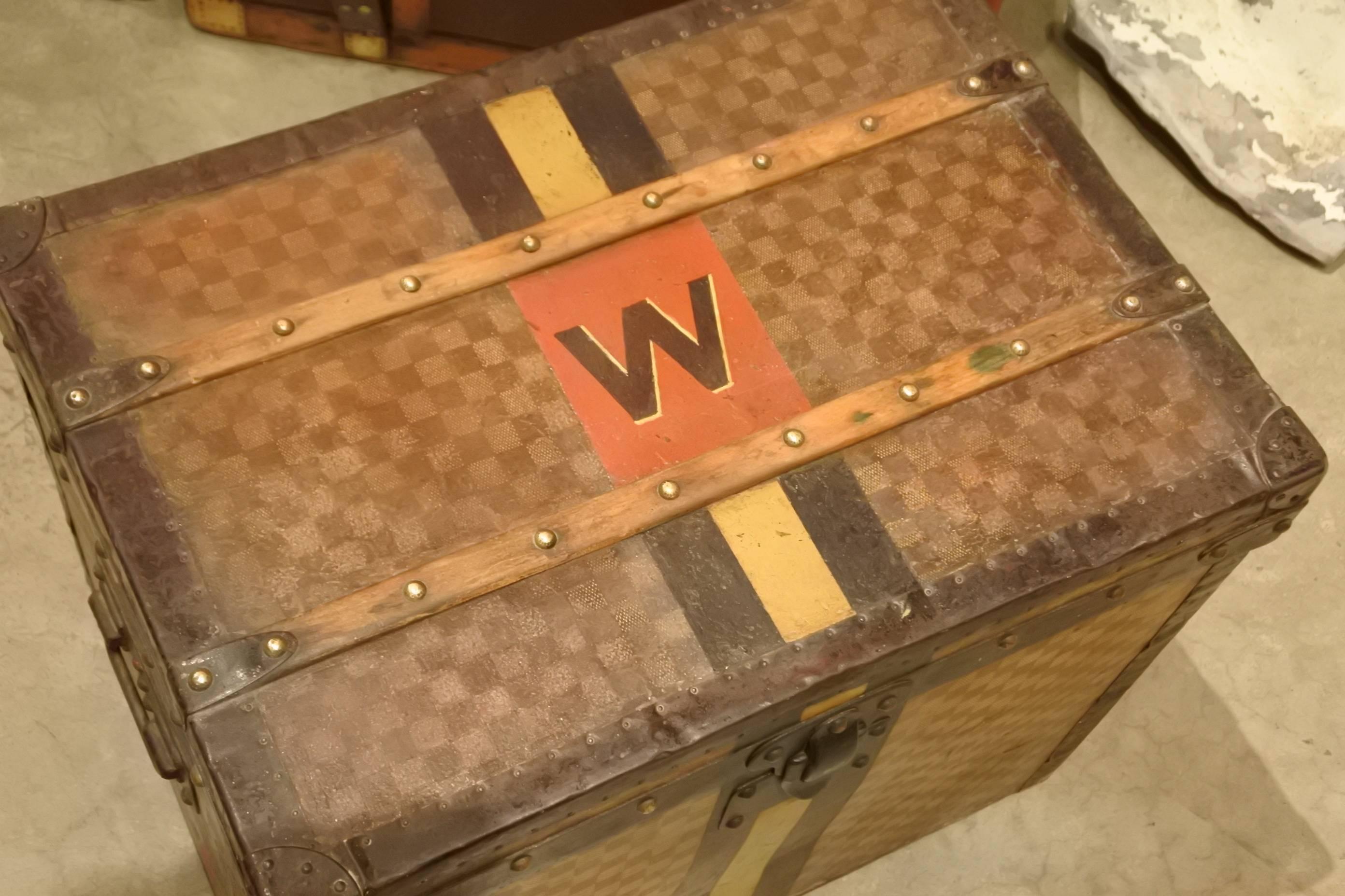 Rare Louis Vuitton Damier trunk with original monogram and striping. Perfect size for a side or end table. These trunks bear the character and craftsmanship of traveling with style in the old-world.