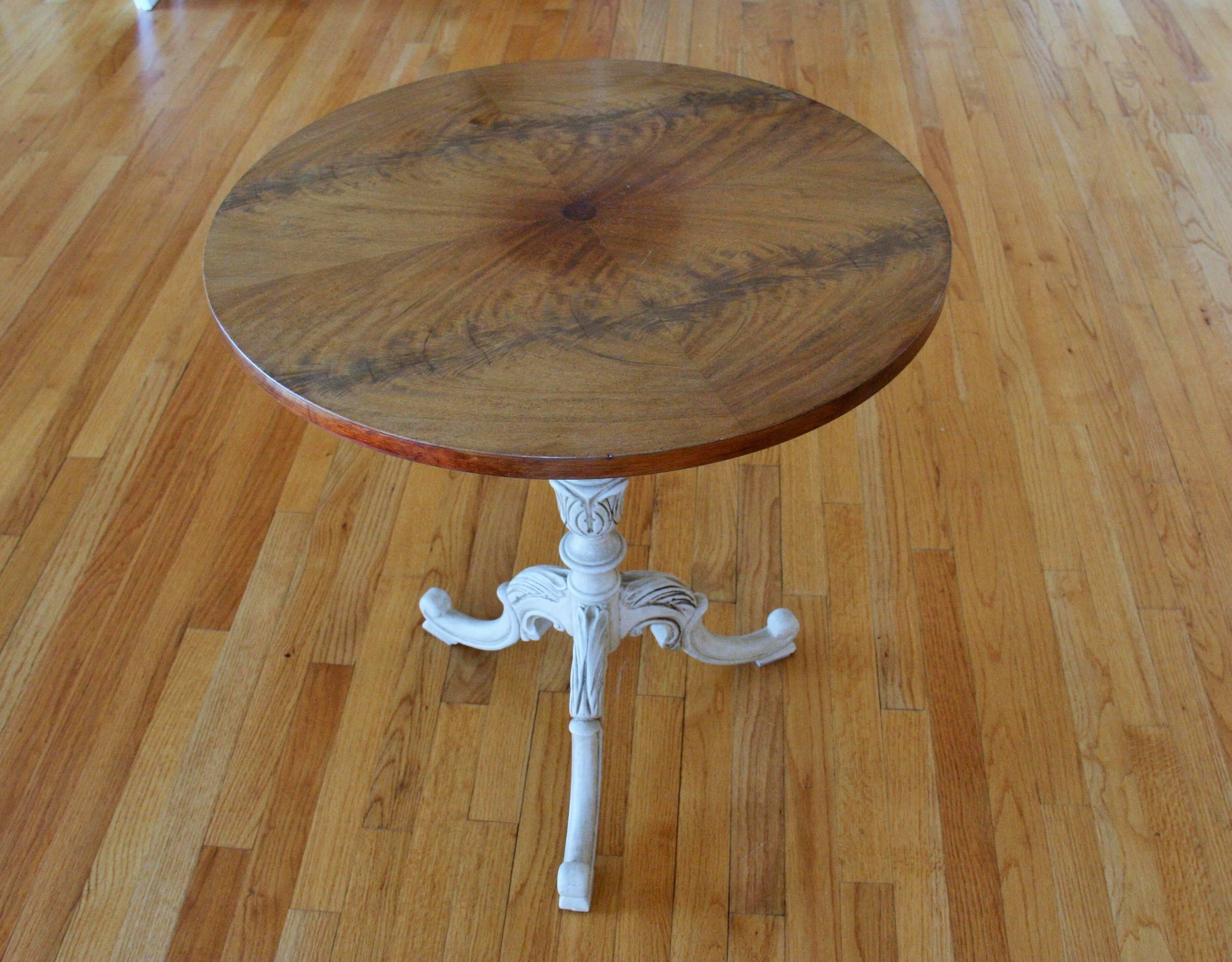 Carved painted pedestal supporting mahogany veneered top.