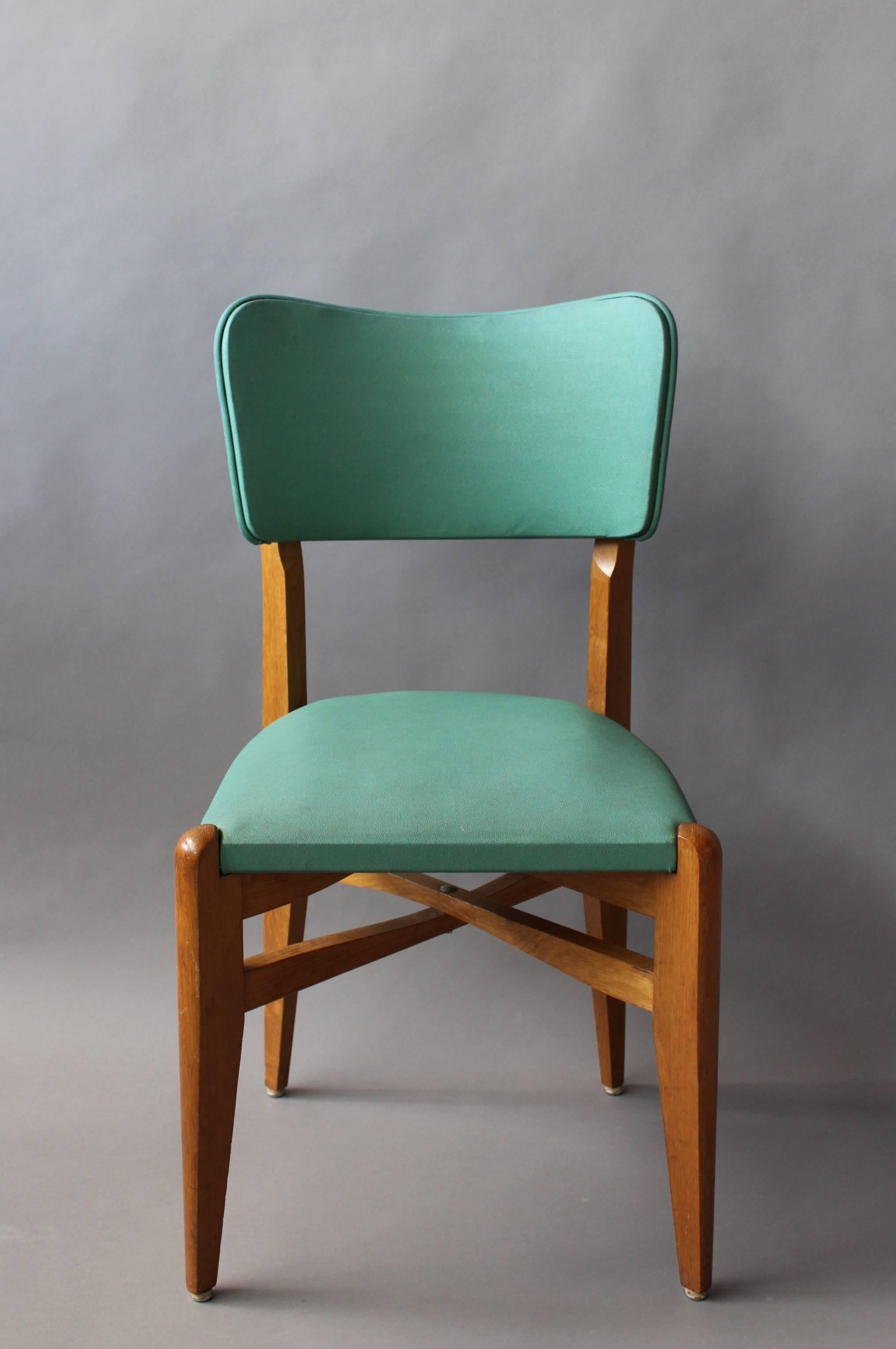 A set of 6 French 1950s green vinyl upholstered oak chairs.