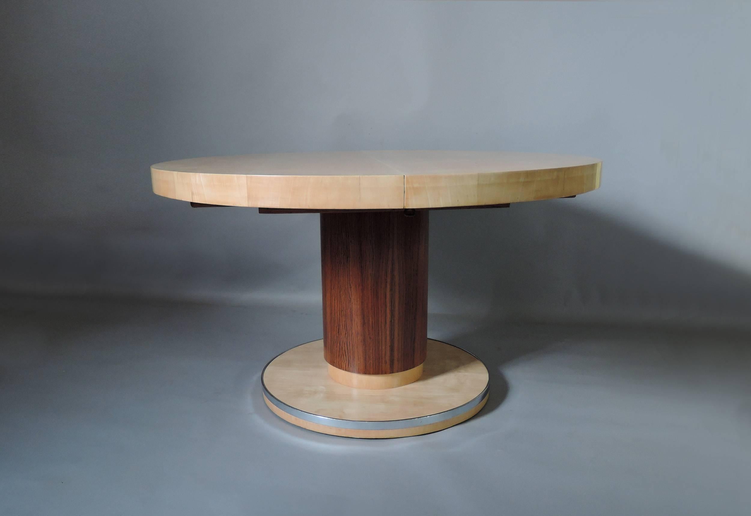 A fine Belgian Art Deco round dining table with a sycamore top and rosewood and sycamore pedestal base with a chrome edge.
Possibility of center leaves (to be made), full length would be 94