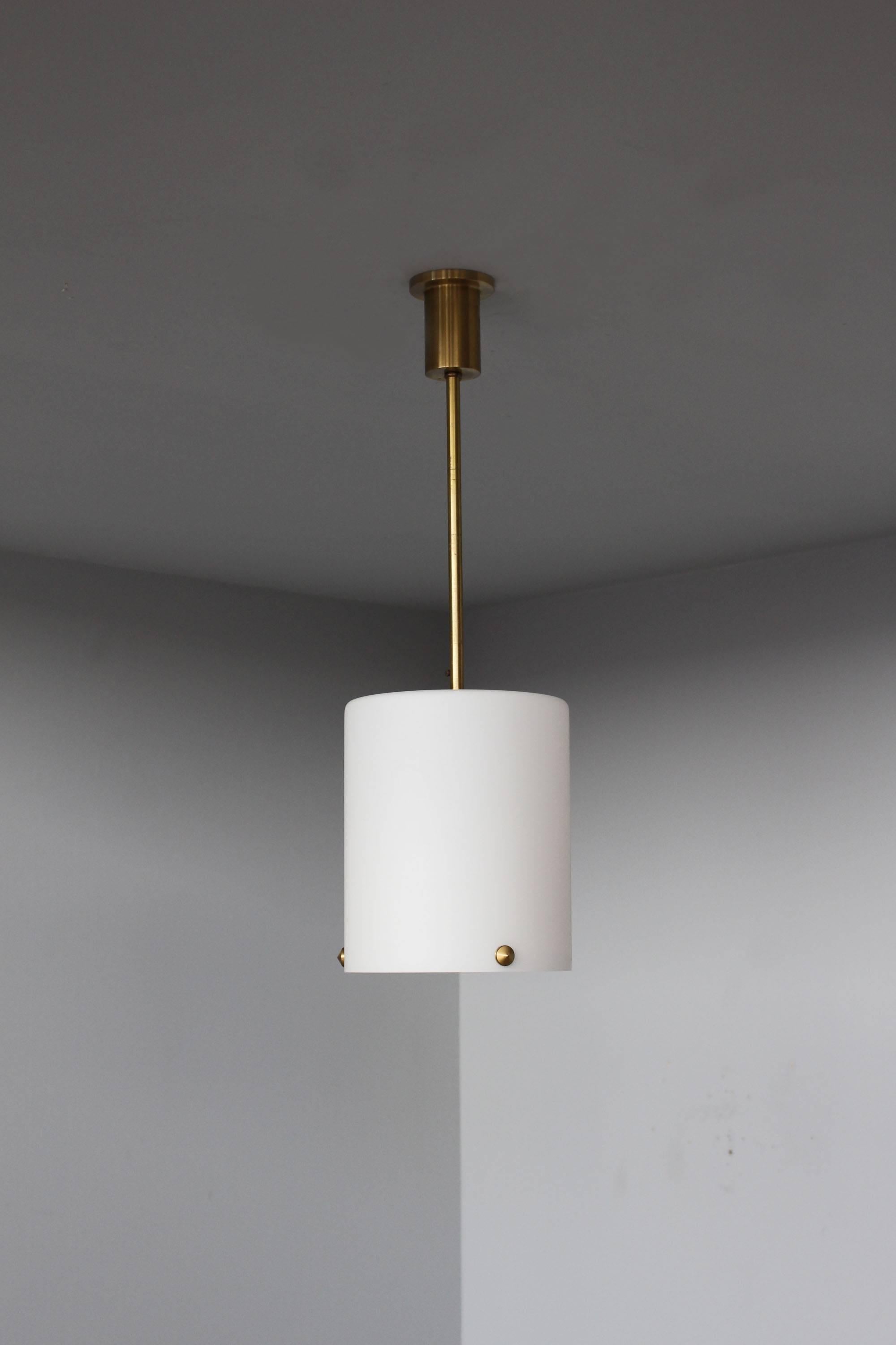 With a satin enameled cylinder glass, which is decorated with three bronze studs that support the prismatic glass lens. Suspended by a bronze rod and canopy.
  