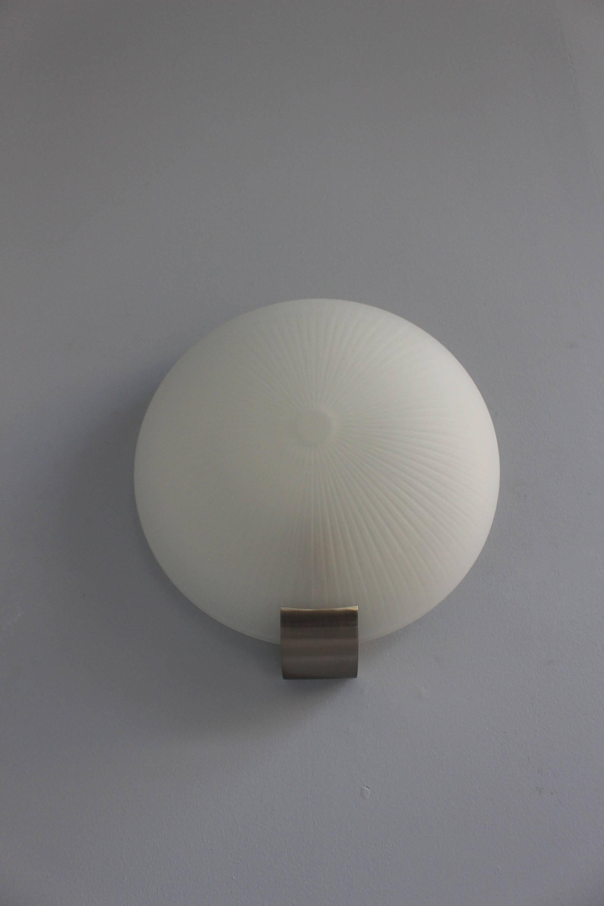 With a fluted round frosted glass shade mounted on a brushed chrome base.